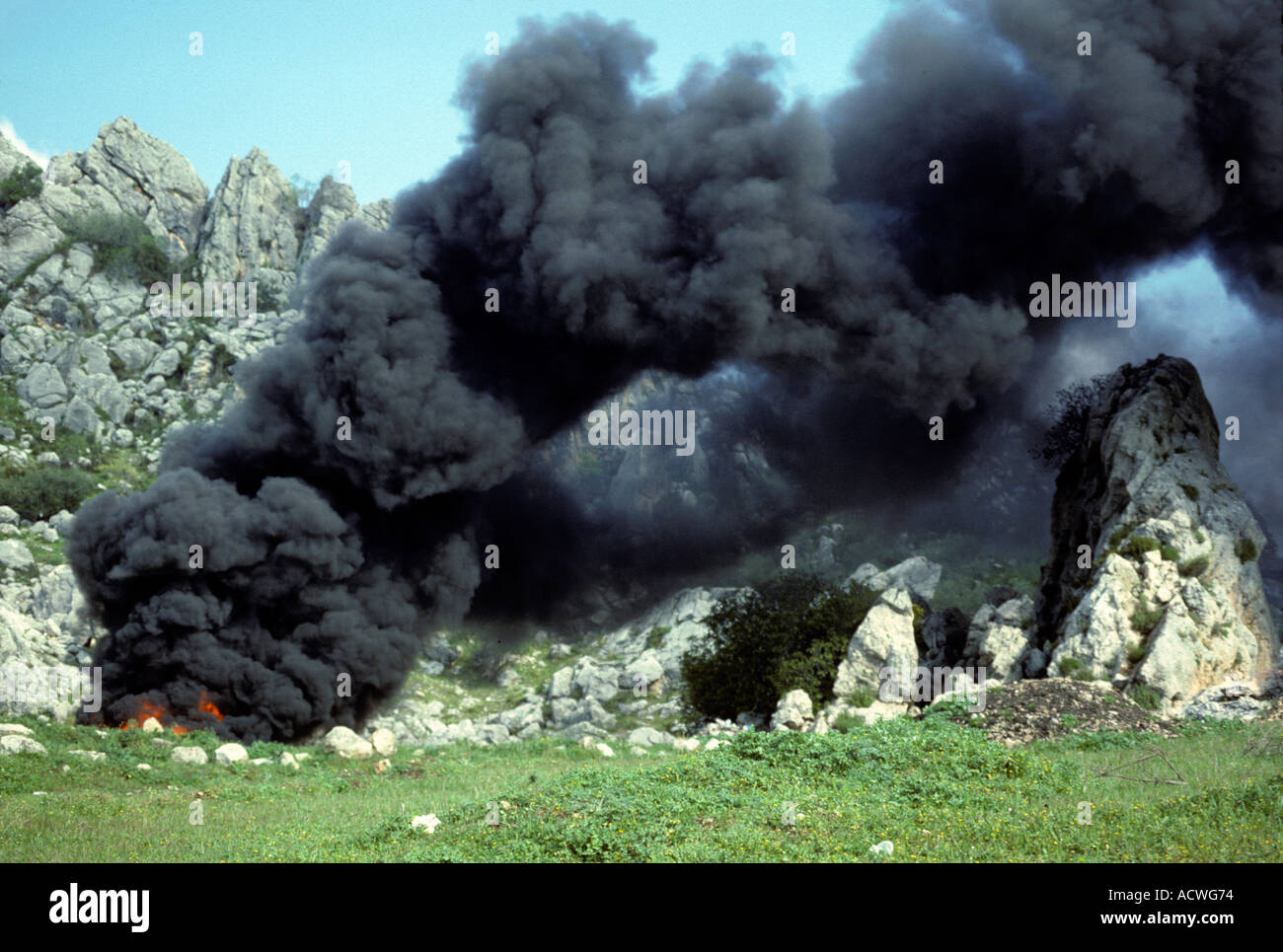 fire in waste dump with car tires smoke emission Spain Stock Photo