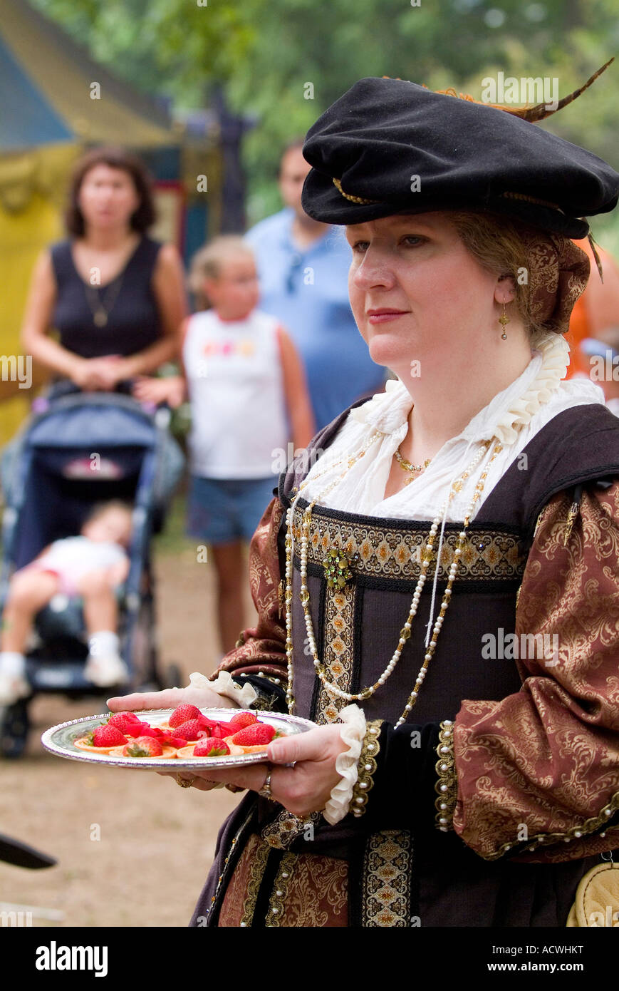 QUEEN'S MAID DRESSED IN ROYAL CLOTHES CARRYING A TREAT FOR HER. Stock Photo
