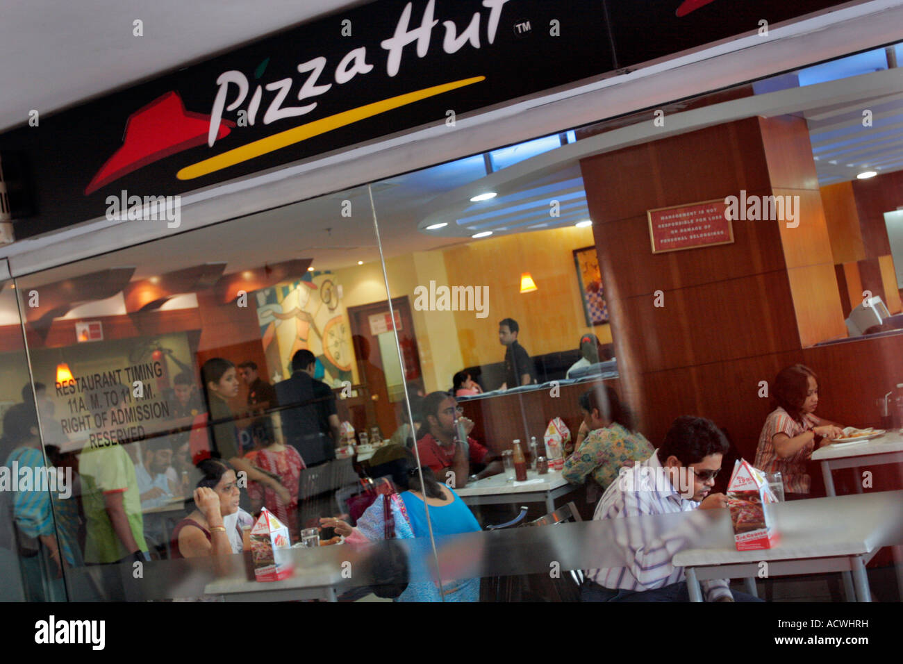 Indians eat at a Pizza Hut restaurant in a modern shopping mall in Salt