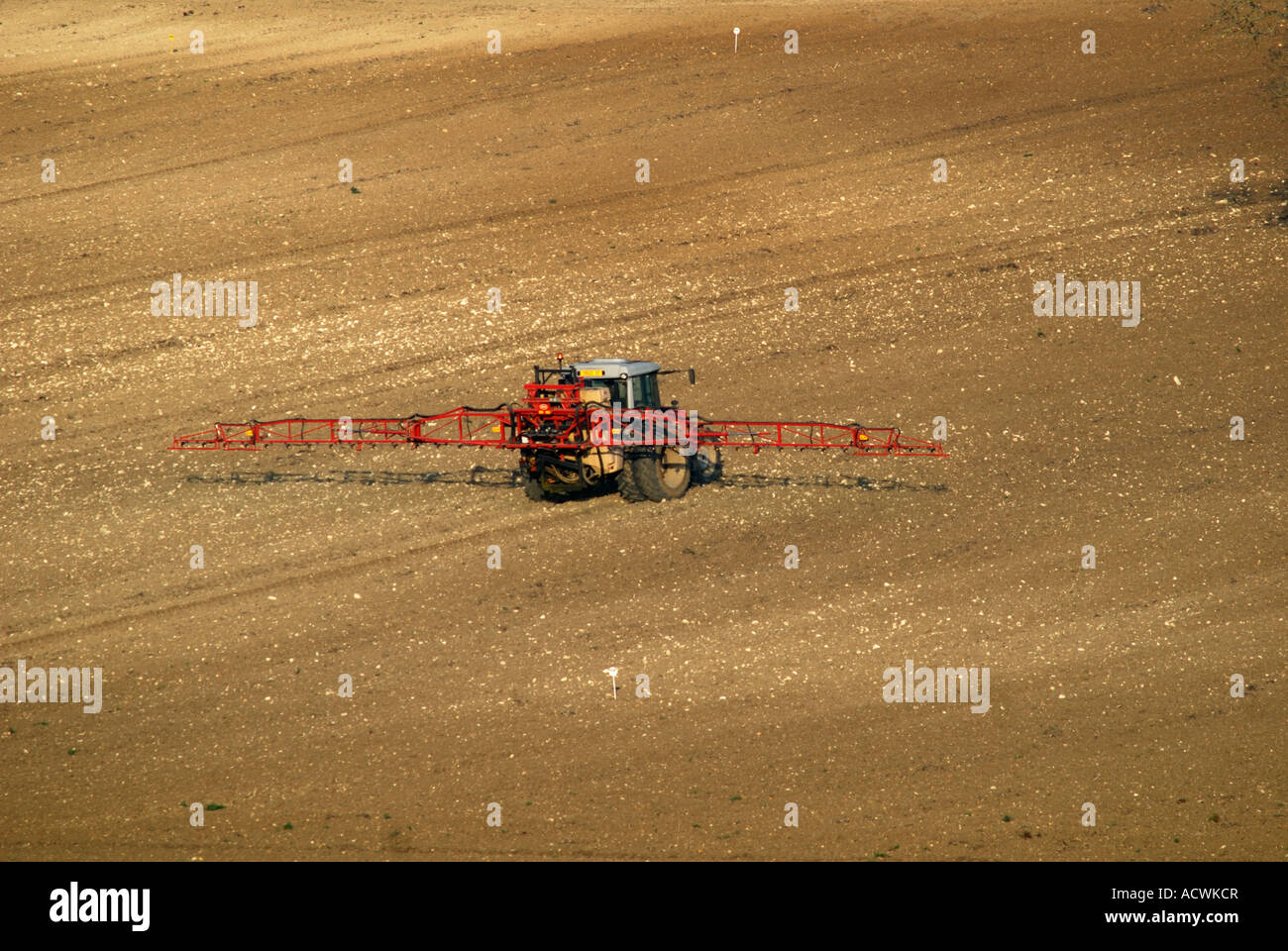 Tractor and spraying boom on farmland after sowing maize; early summer, Indre-et-Loire, France. Stock Photo