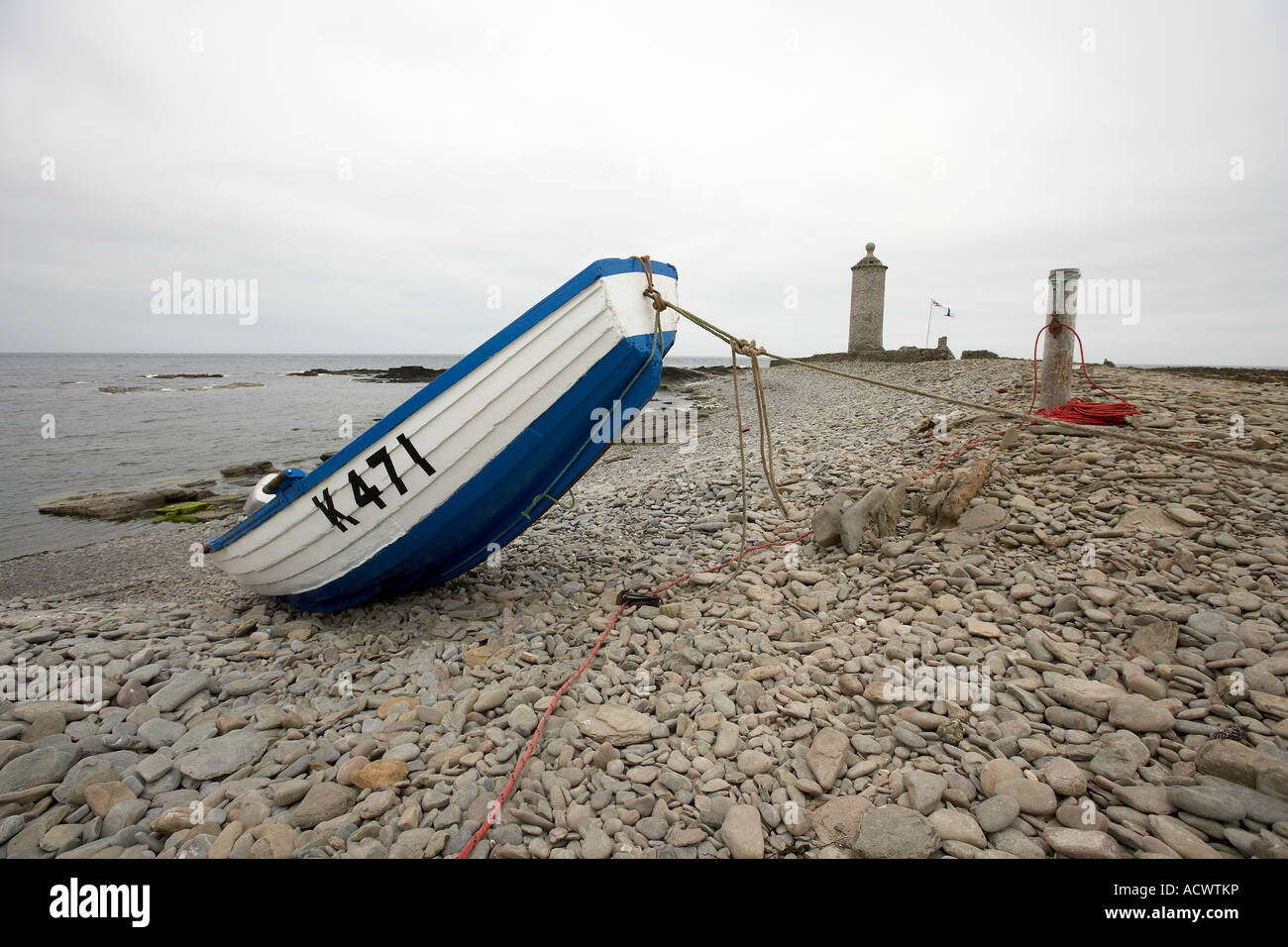Fishing boat next to the old Beacon first built in 1789 North Ronaldsay Orkney Scotland UK Stock Photo