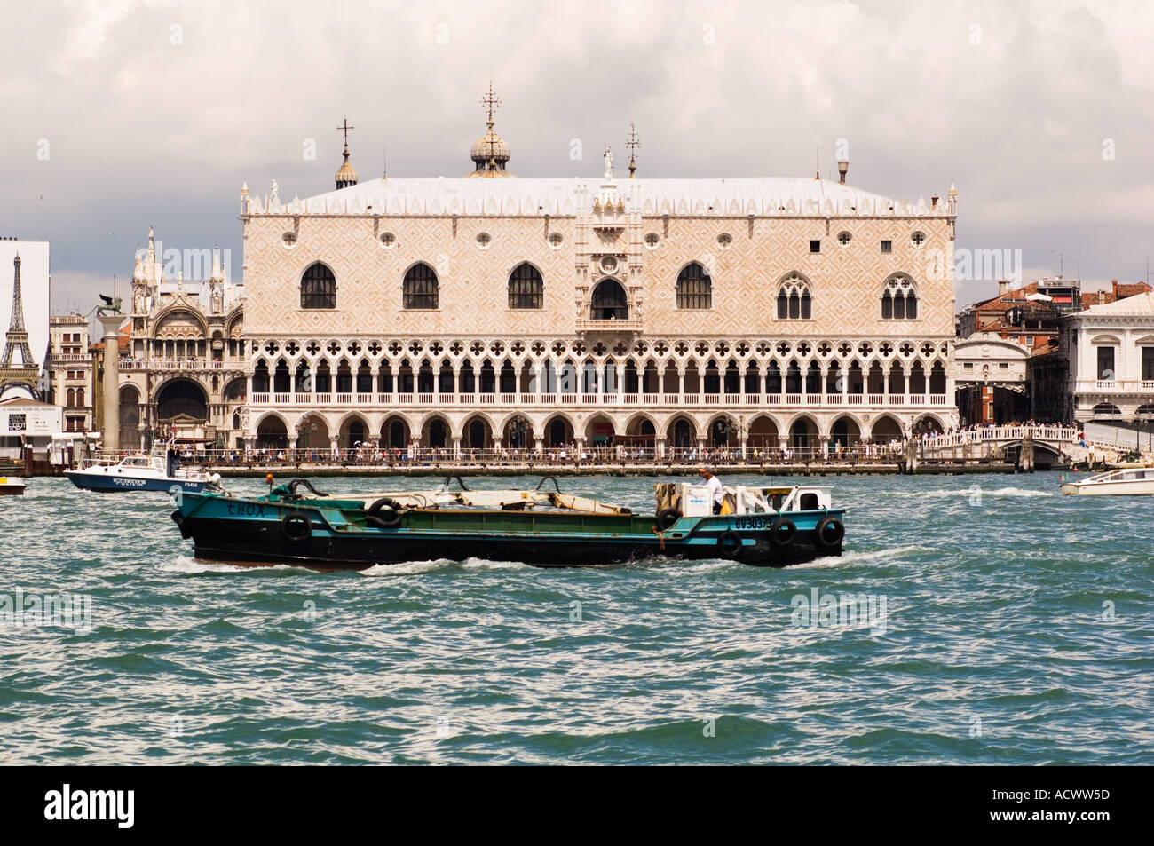 Doges Palace in Sestieri Marco in Venice Italy seen from Canale Della Giudecca with boat traffic in foreground Stock Photo