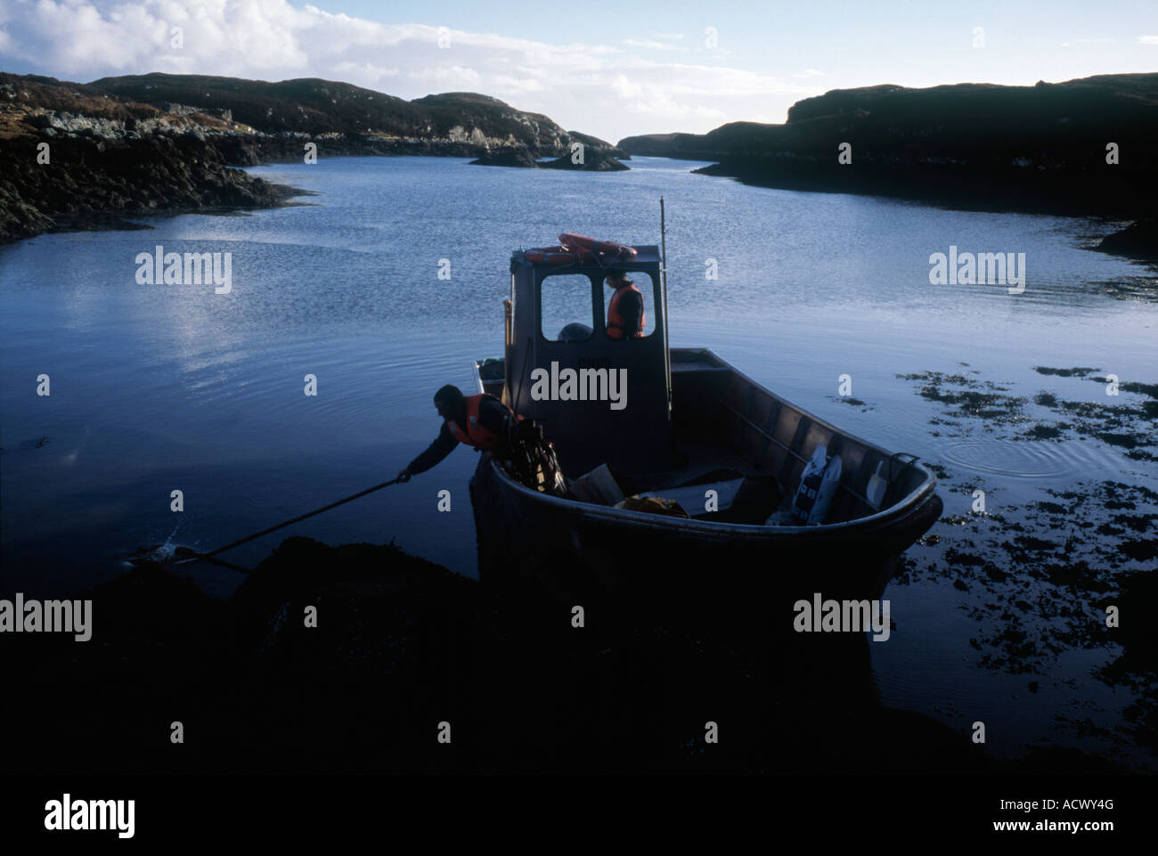 boat in the bay of North Uist western isles scotland enroute to organic salmon fish farm Stock Photo