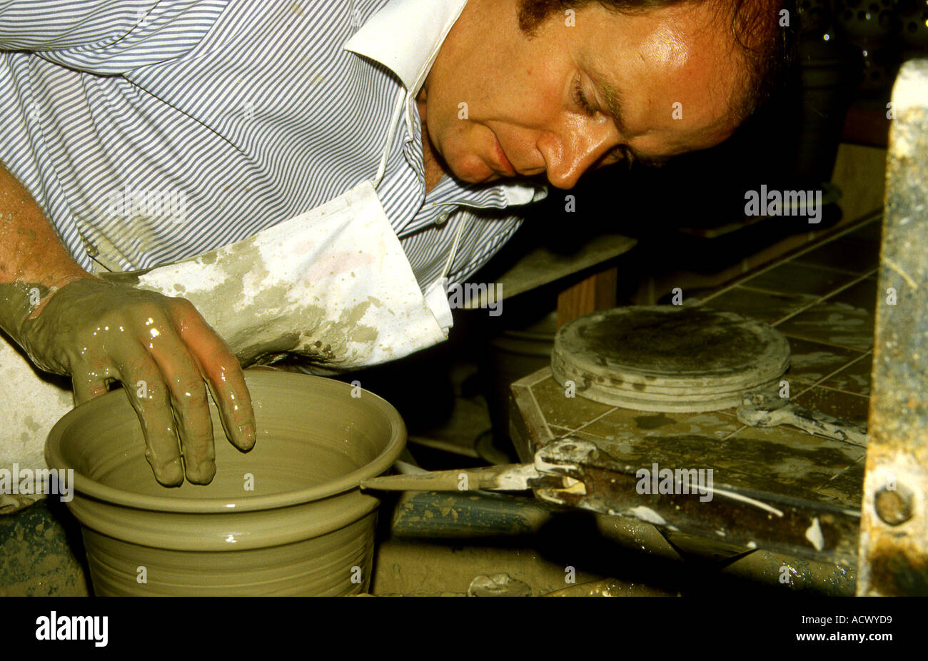 Potter throwing a pot on the revolving wheel Stock Photo Alamy