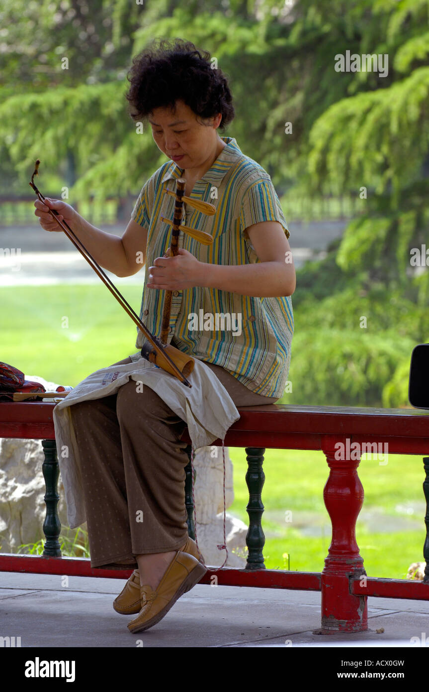 A woman playing the Erhu in a pavilion in the Temple of Heaven Park in Beijing Stock Photo