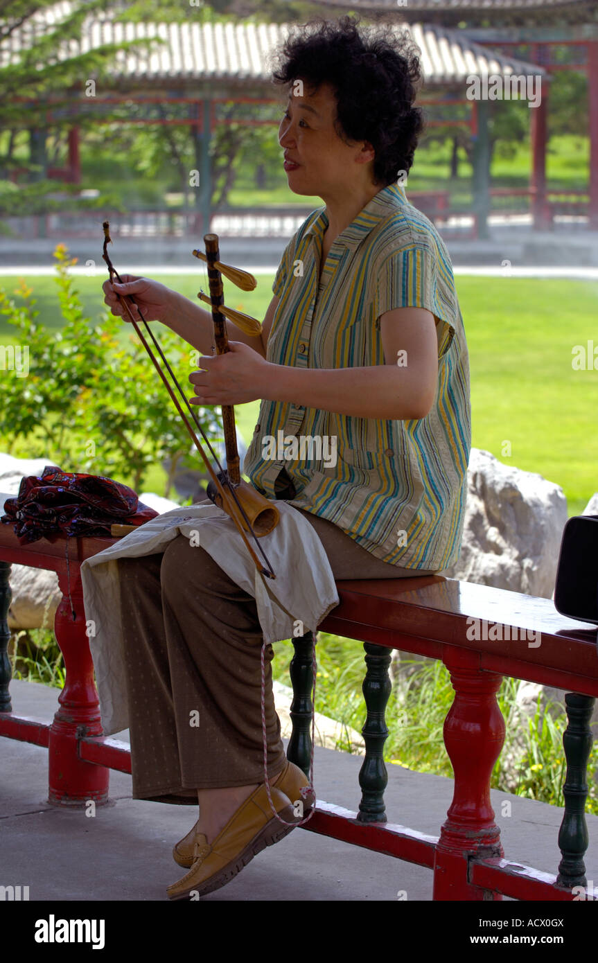 A woman playing the Erhu in the Temple of Heaven Park in Beijing Stock Photo