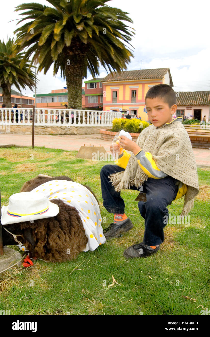 child eating in company of his dressed sheep, Soracá, Colombia Stock Photo