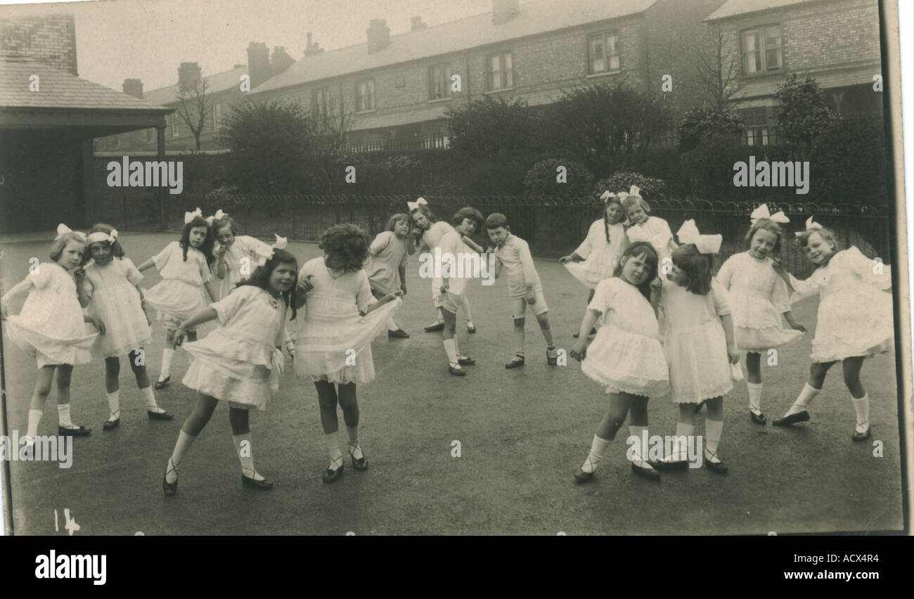 Photographic postcard of children in school dancing class circa 1910 Stock Photo