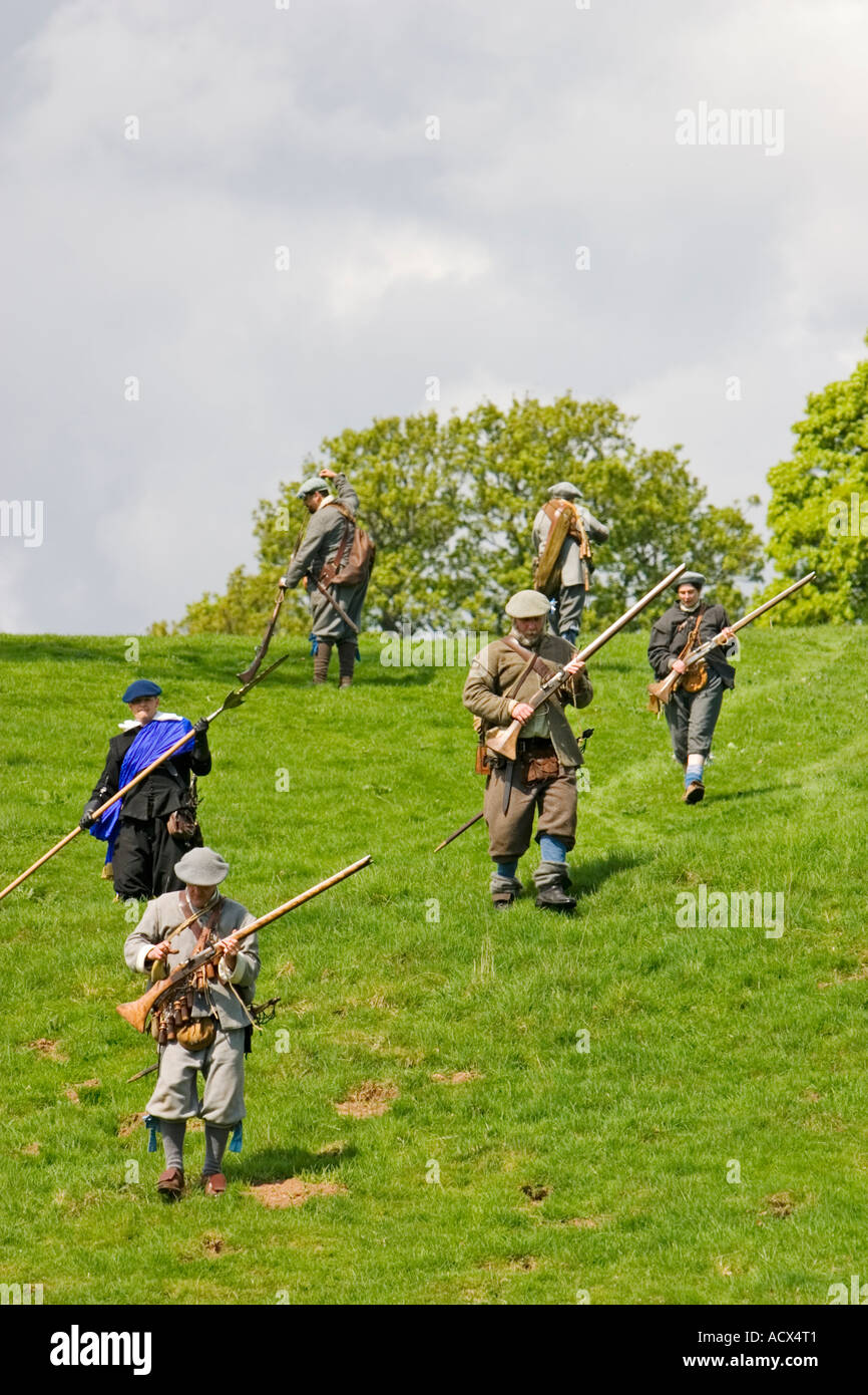 Covenanter troops in uniform return to camp after skirmish, muskets in hand Stock Photo