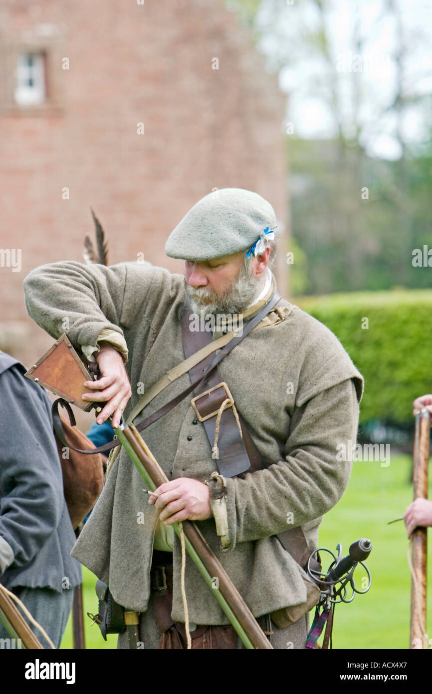 Covenanter soldier loads musket with gunpowder Stock Photo Alamy