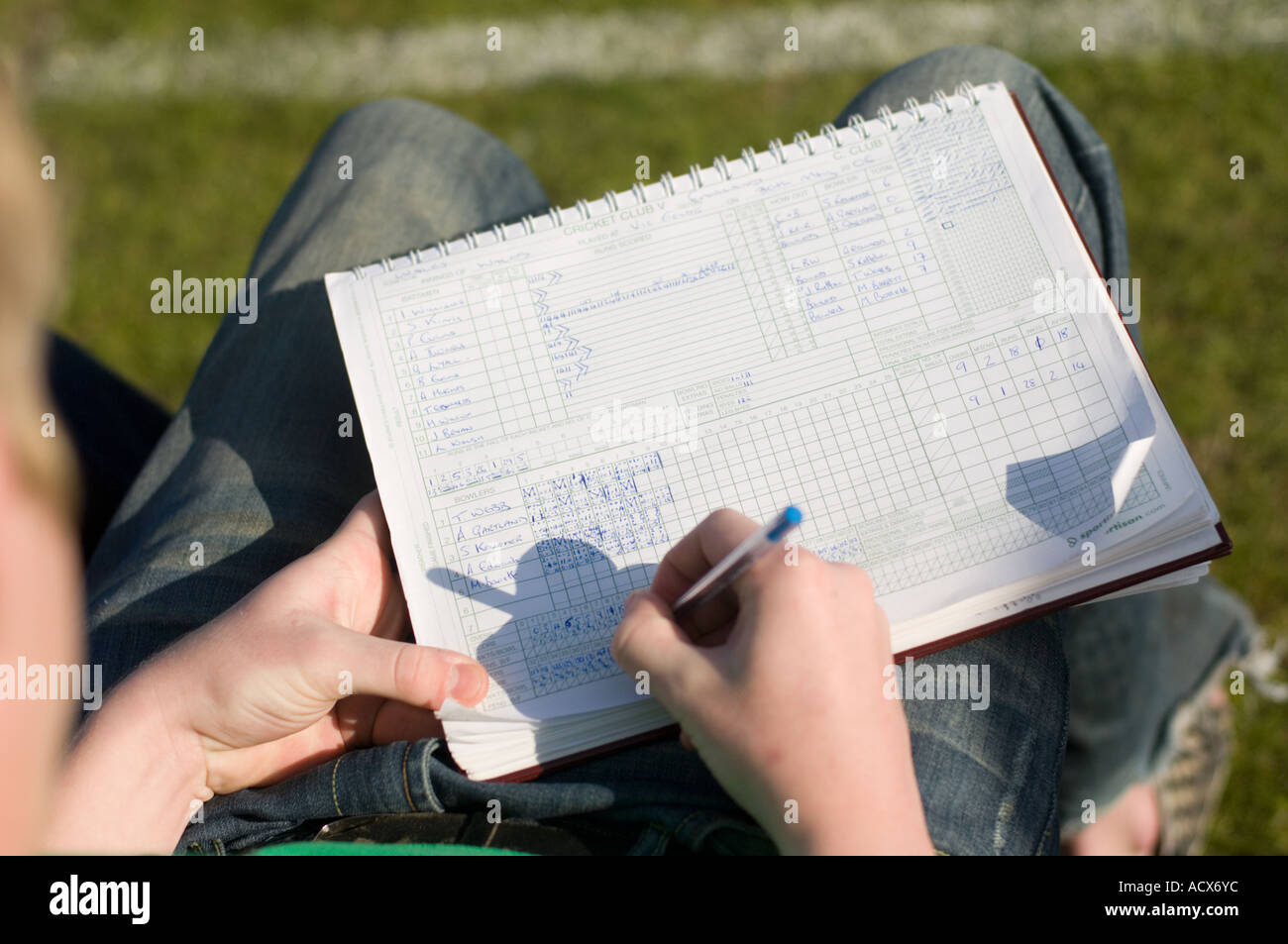 Cricket score analysis : over the shoulder shot of man scoring at a game of cricket , uk Stock Photo