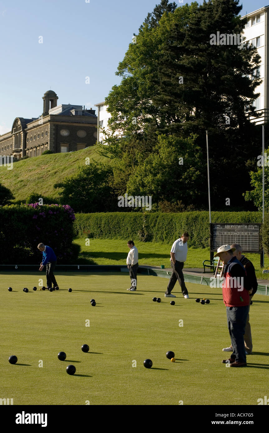 Men playing bowls in Aberystwyth with the University of Wales school of art in the background Stock Photo