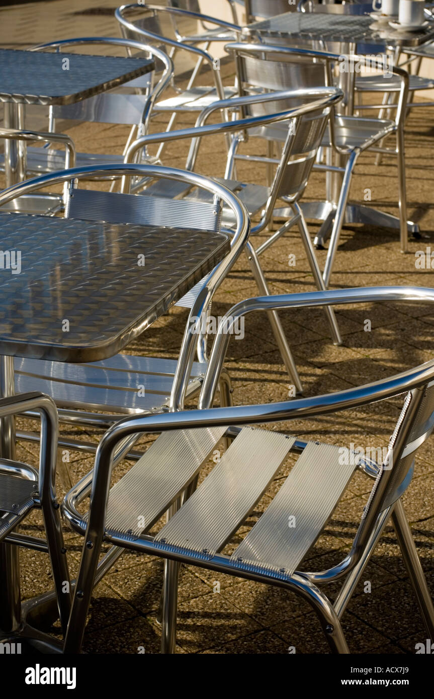 aluminium aluminum bistro furniture tables and chairs - in a deserted pavement cafe Stock Photo