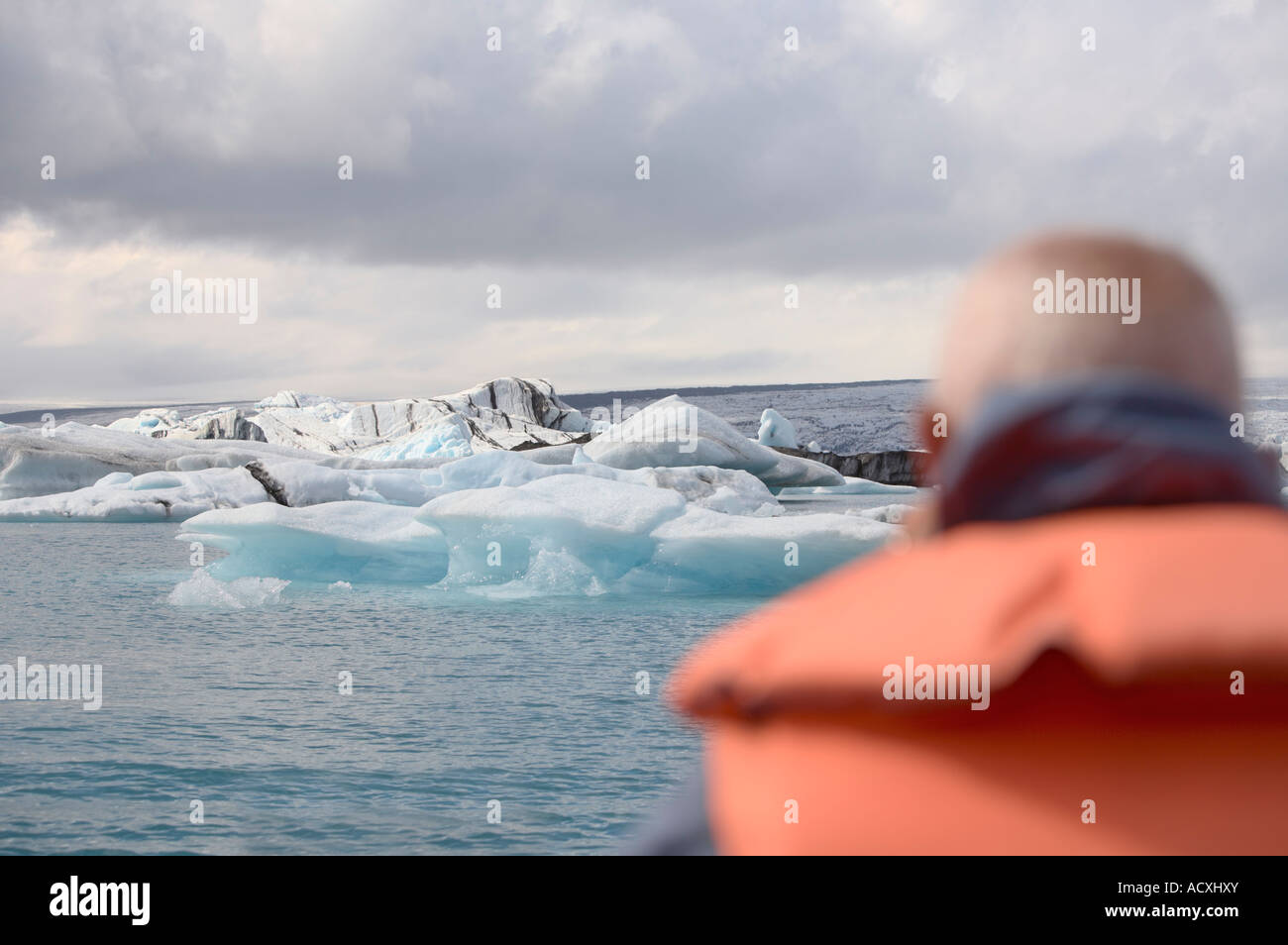 A tourist watching icebergs in the Jokulsarlon glacial lagoon in the Skaftafell National Park, Iceland Stock Photo
