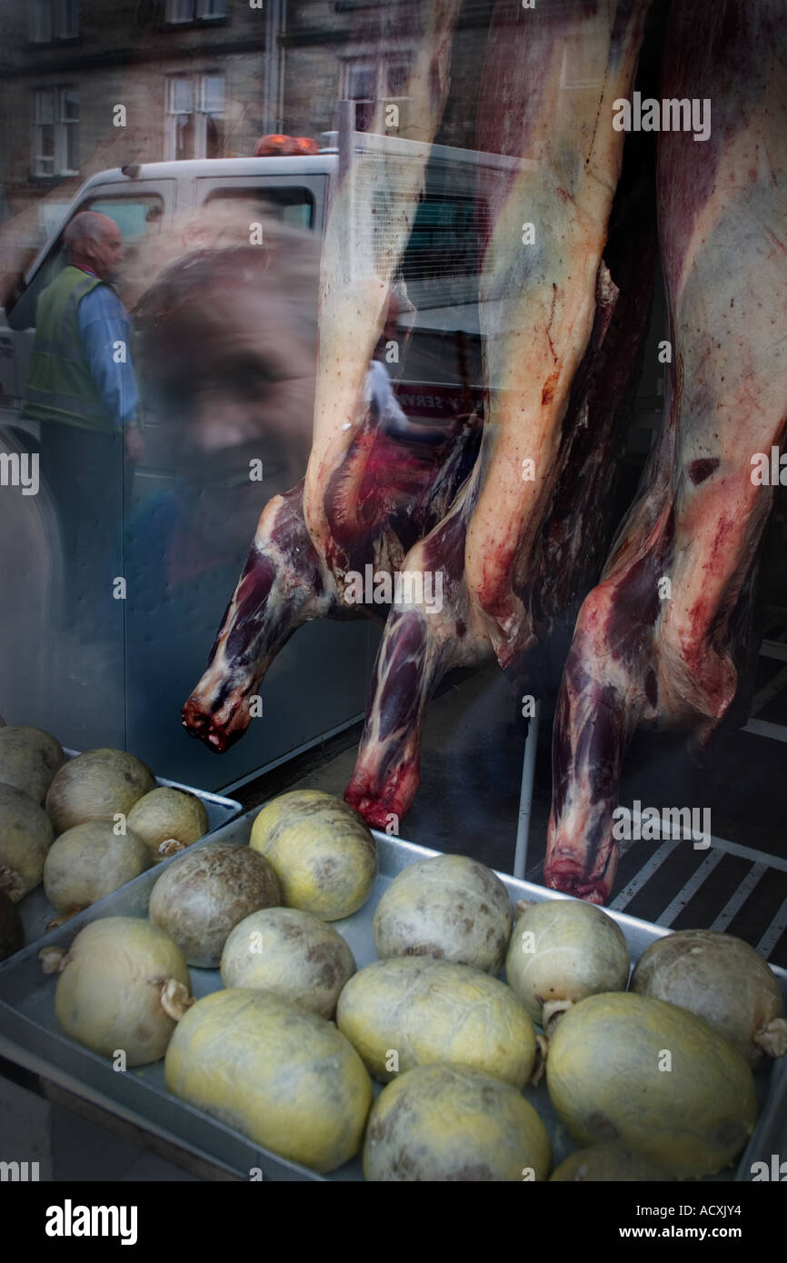 A woman looking inside a meat shop in St. Andrews, Scotland Stock Photo