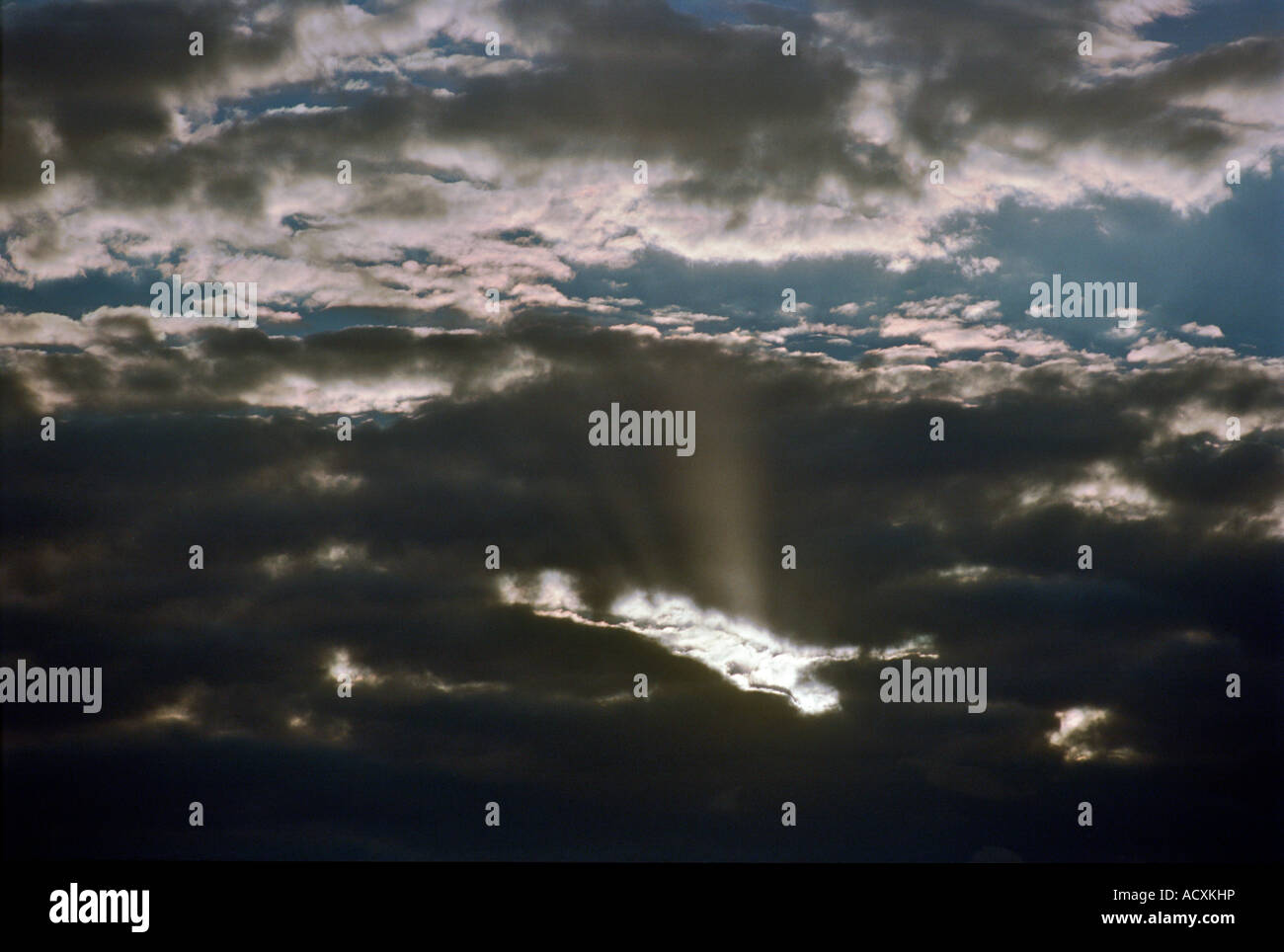 Sun shining through dark clouds Stock Photo - Alamy