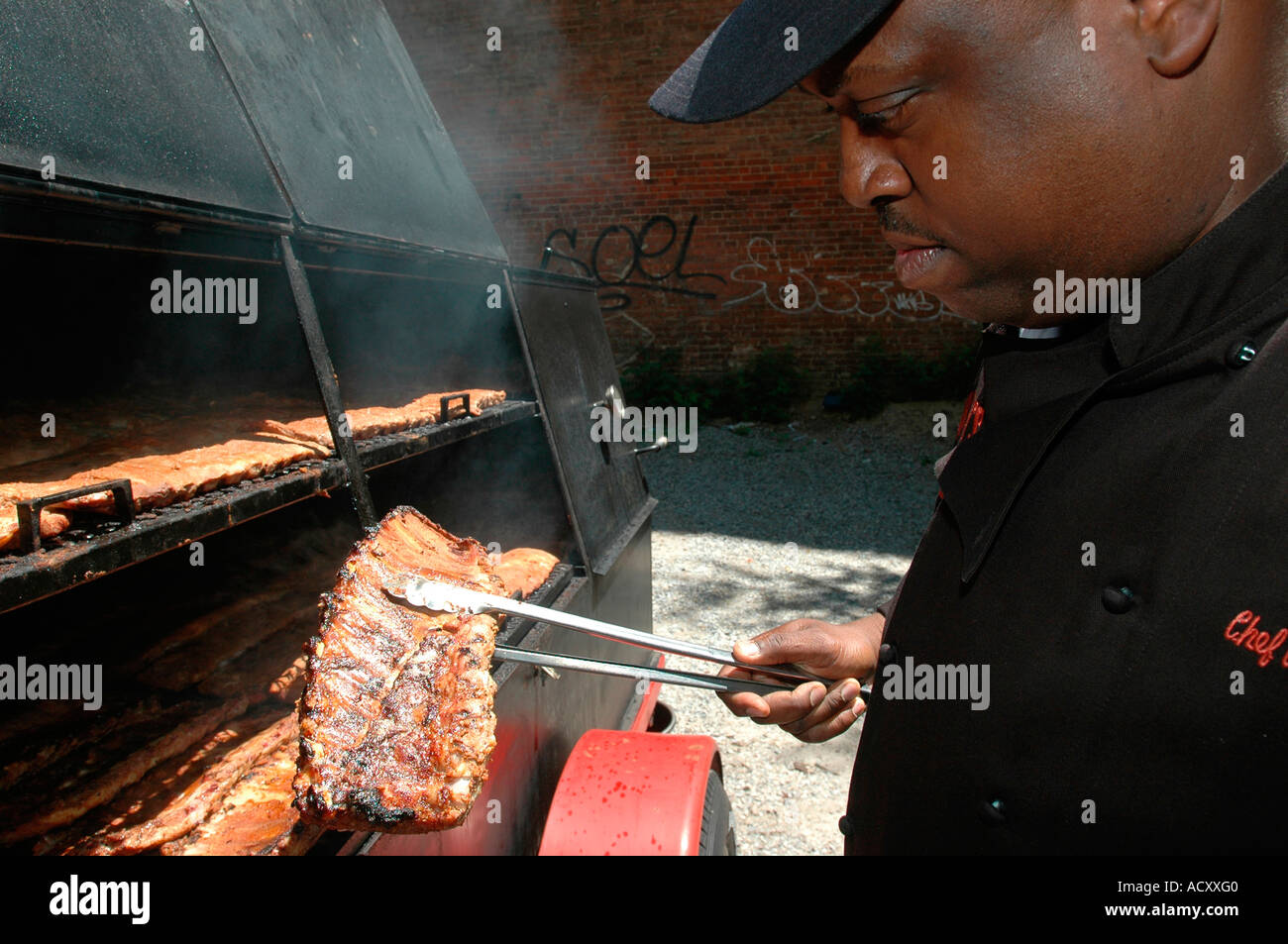 Chef de cuisine prepares St Louis pork ribs bourbon glazed BBQ spare ribs in Amy Ruth s Restaurant smoker in Harlem Stock Photo