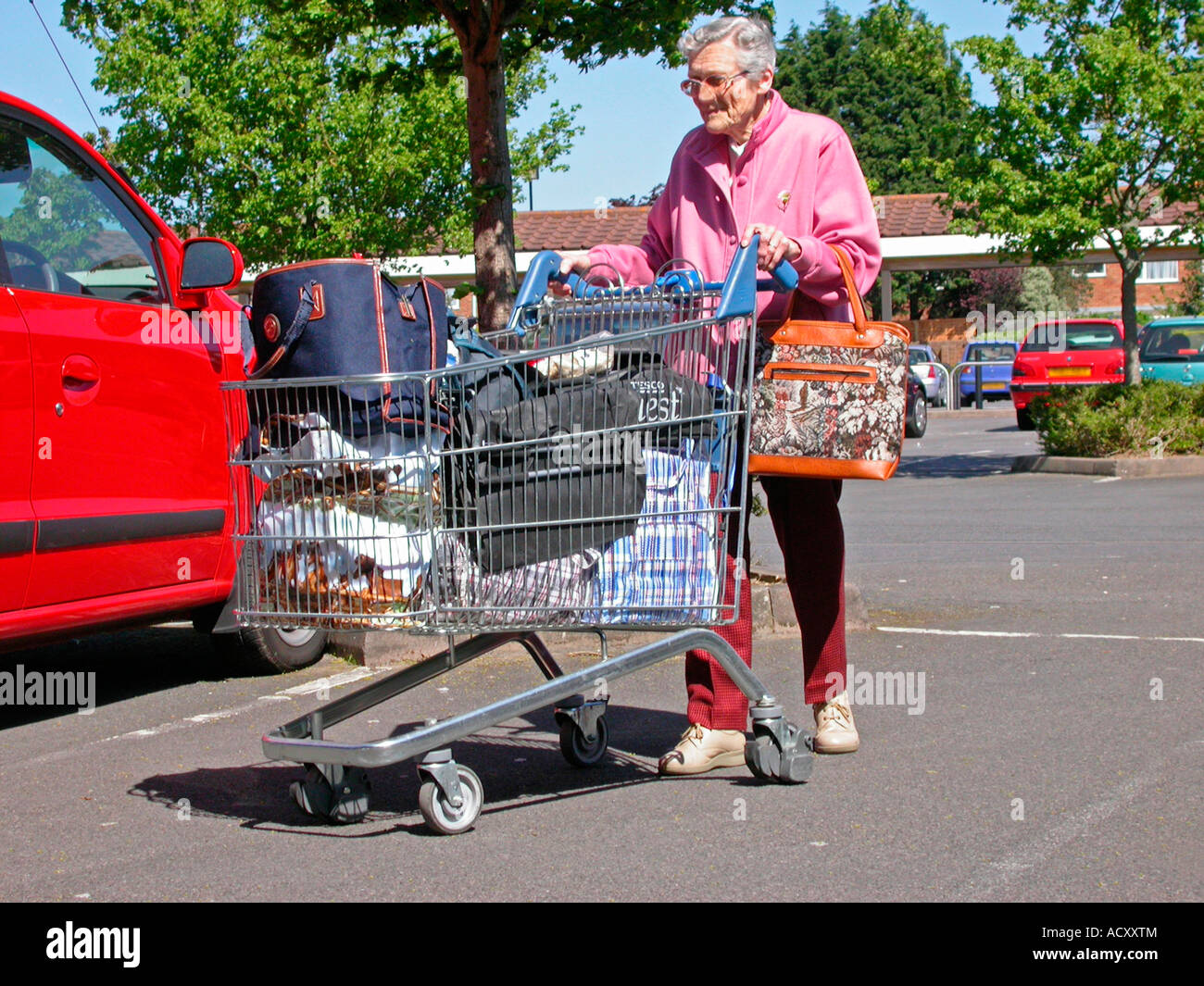 Old woman pushing shopping trolley hires stock photography and images