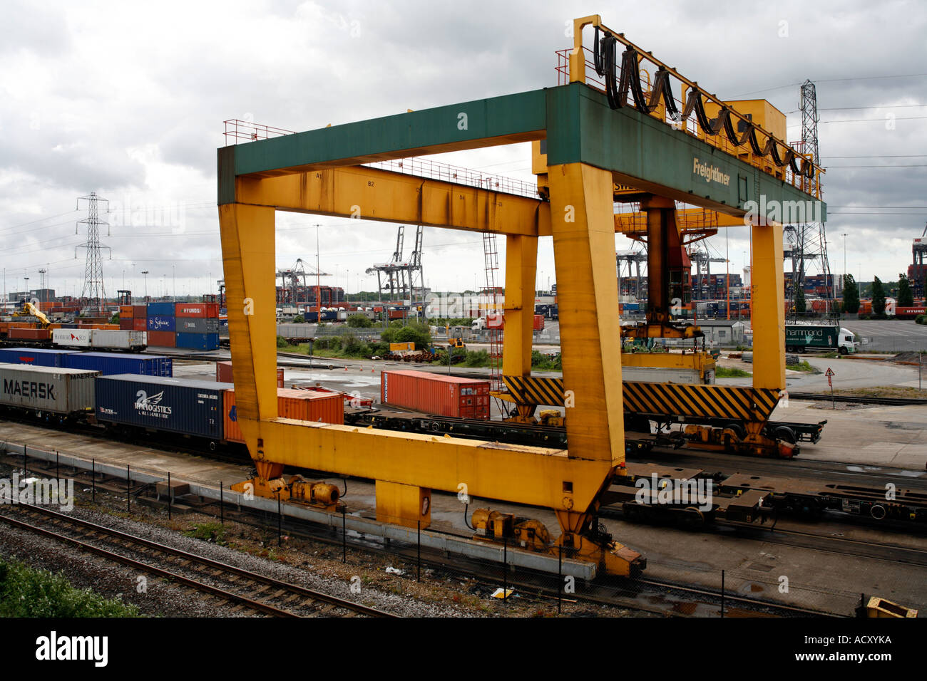 Rail mounted crane loading containers from rail carriages onto truck at