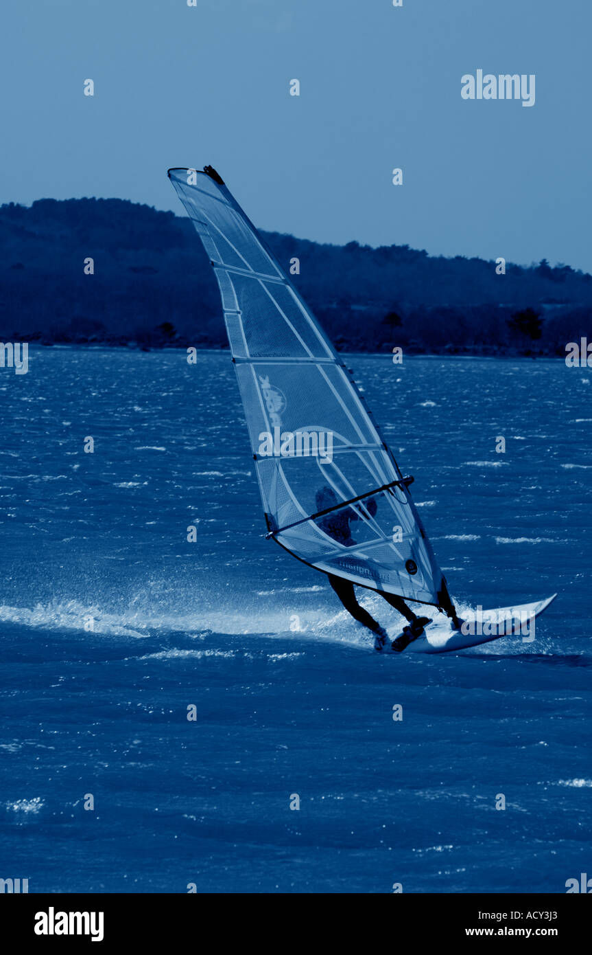 Blue toned image of a Windsurfer in Poole Harbour England UK Stock Photo