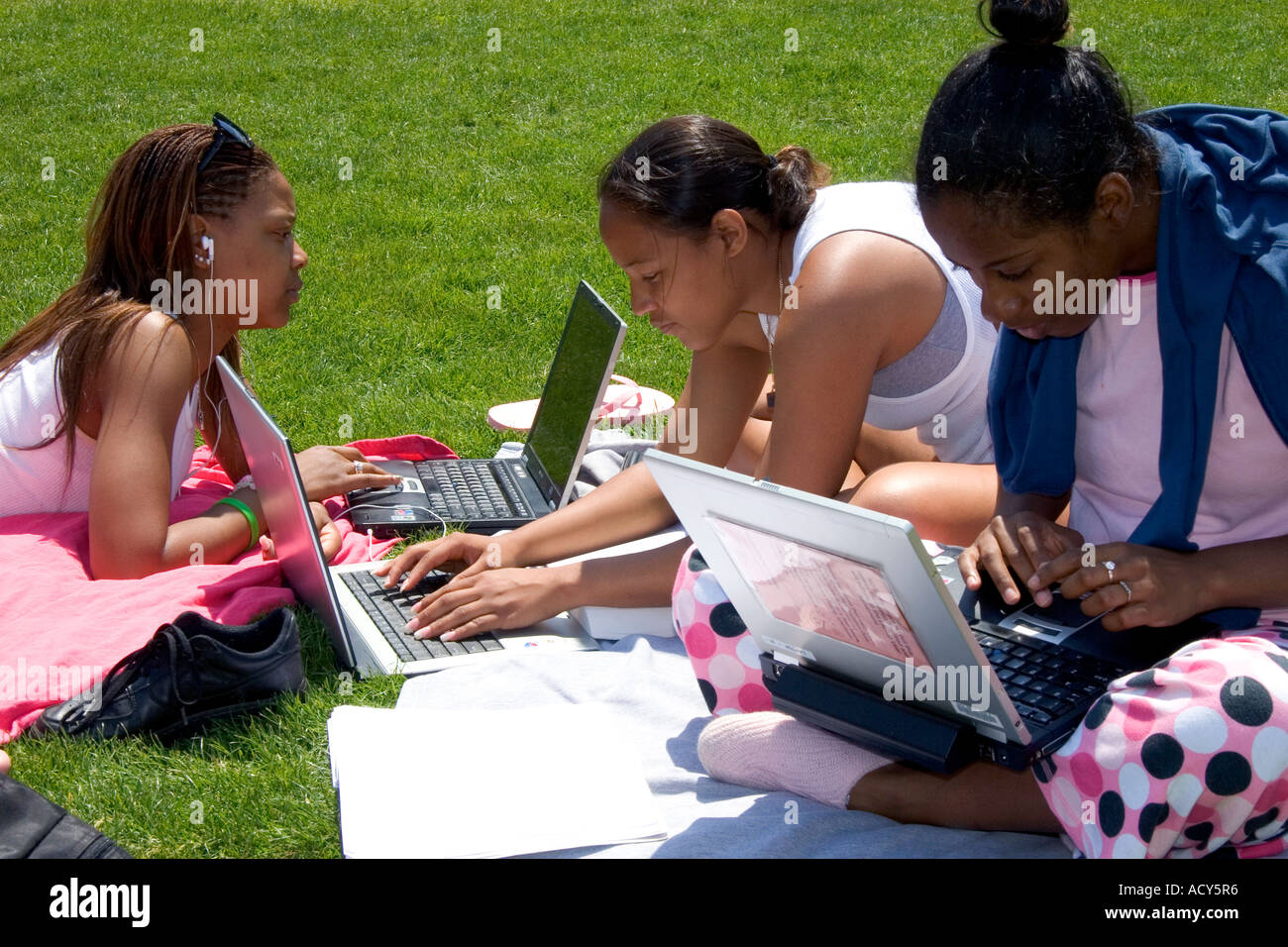 African american female students study using laptop computers on the lawn of Albion College in Michigan. Stock Photo