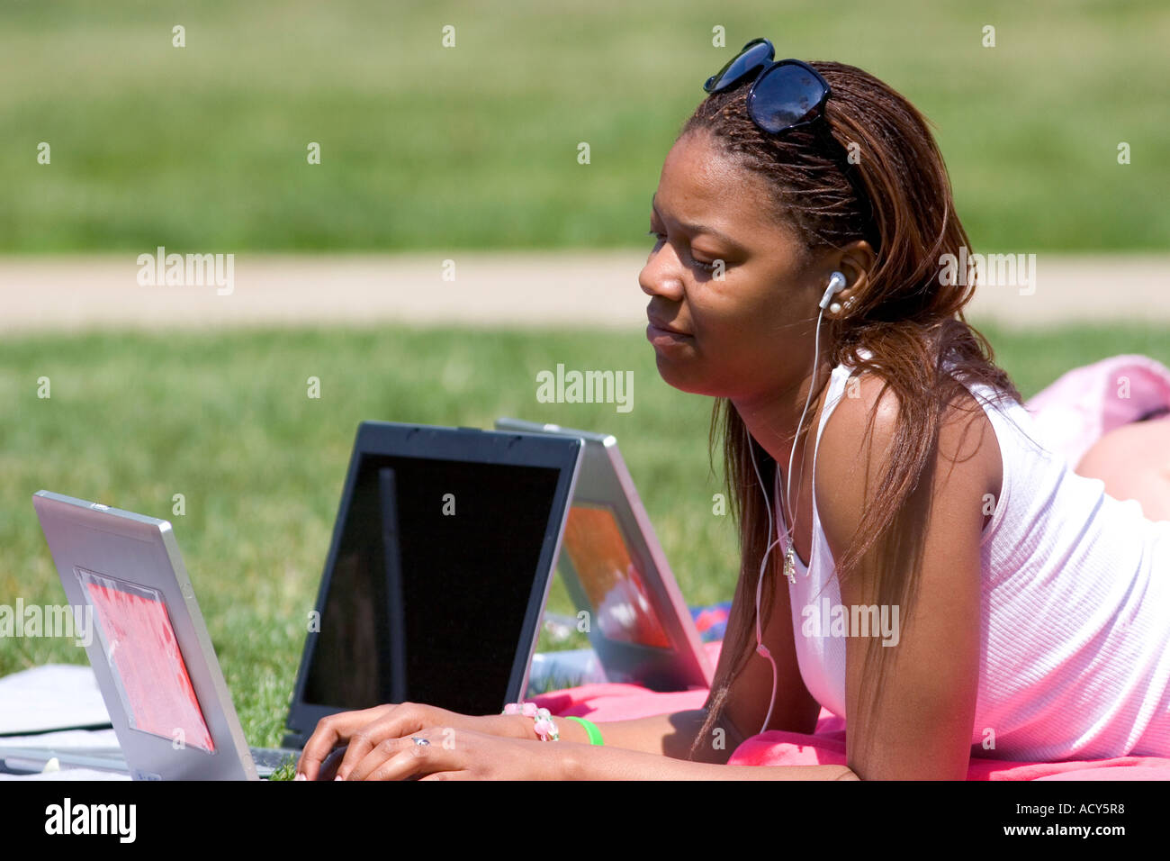 African american female students study using laptop computers on the lawn of Albion College in Michigan. Stock Photo
