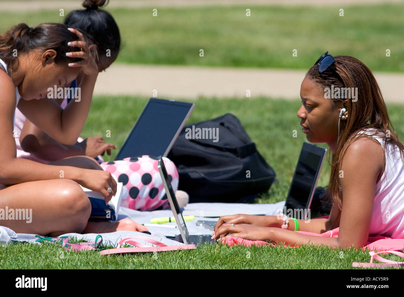 African american female students study using laptop computers on the lawn of Albion College in Michigan. Stock Photo