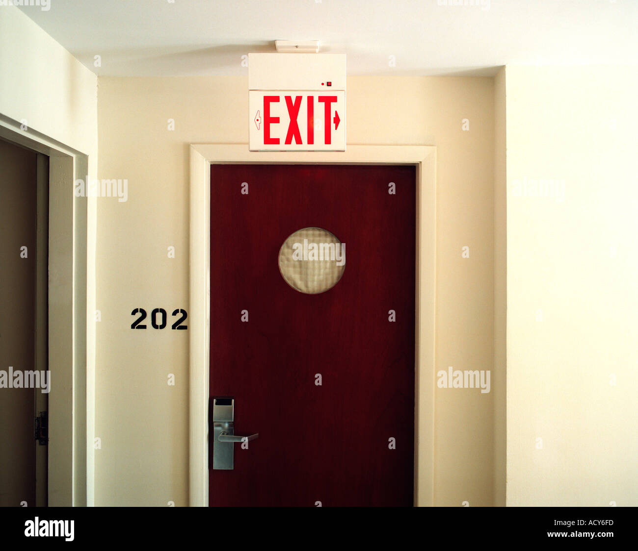 Hotel Room Door And Exit Sign Hanging On The Ceiling Stock Photo