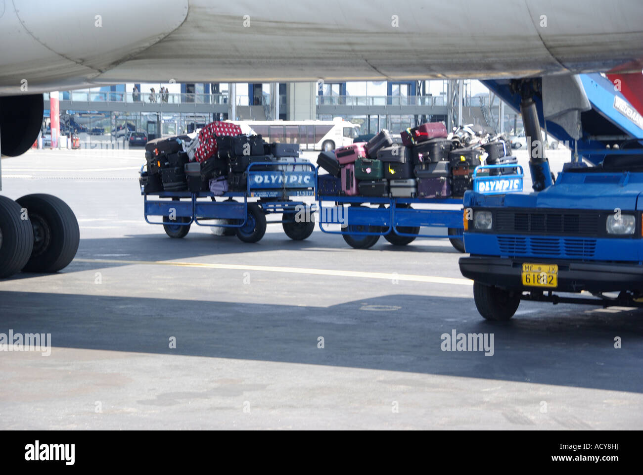 Thessaloniki Greek airport view below airplane fuselage of passengers suitcase luggage on trolleys awaiting loading onto holiday aircraft Greece Stock Photo