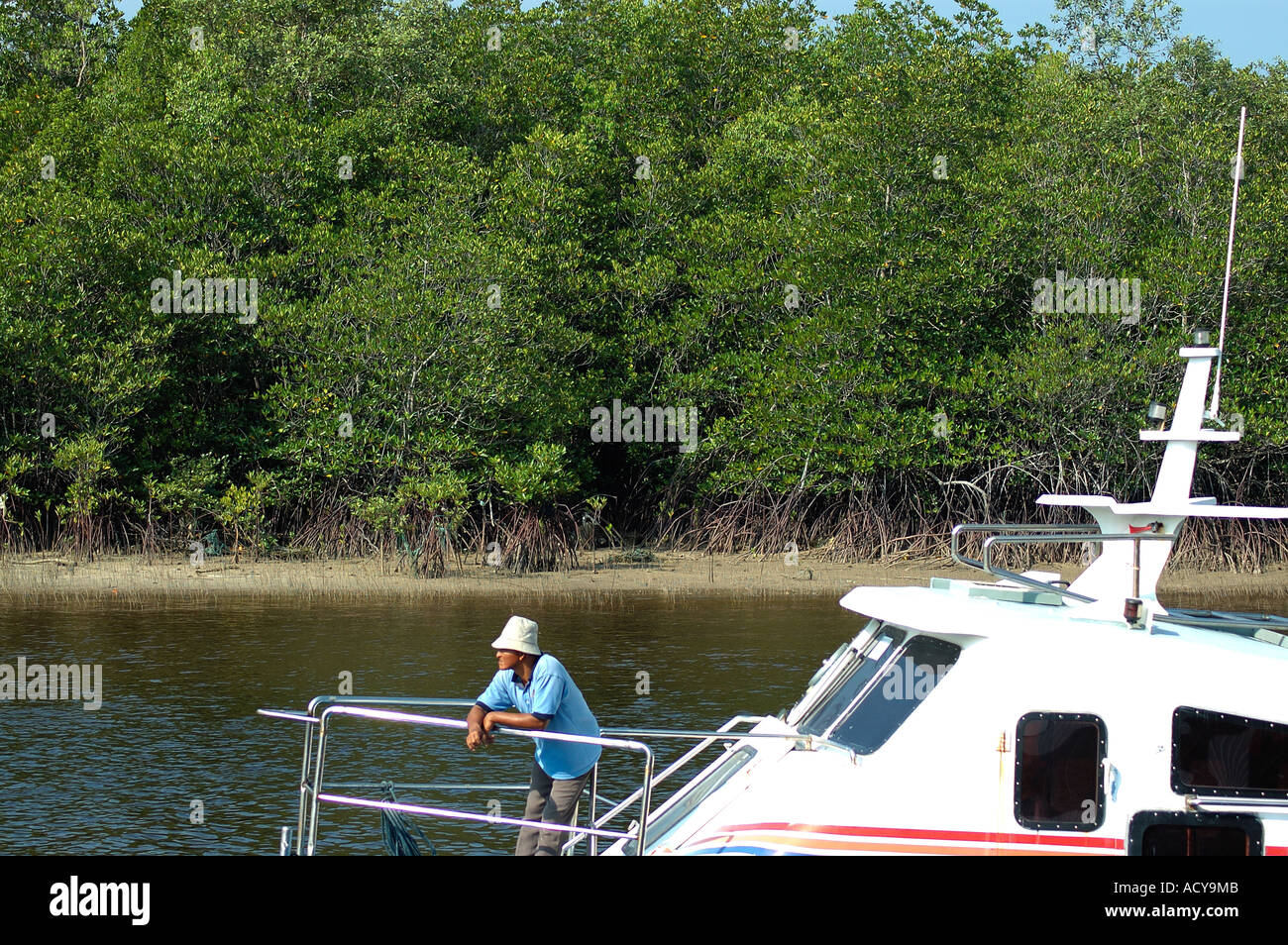 Man in hat looking over speed boat Stock Photo - Alamy