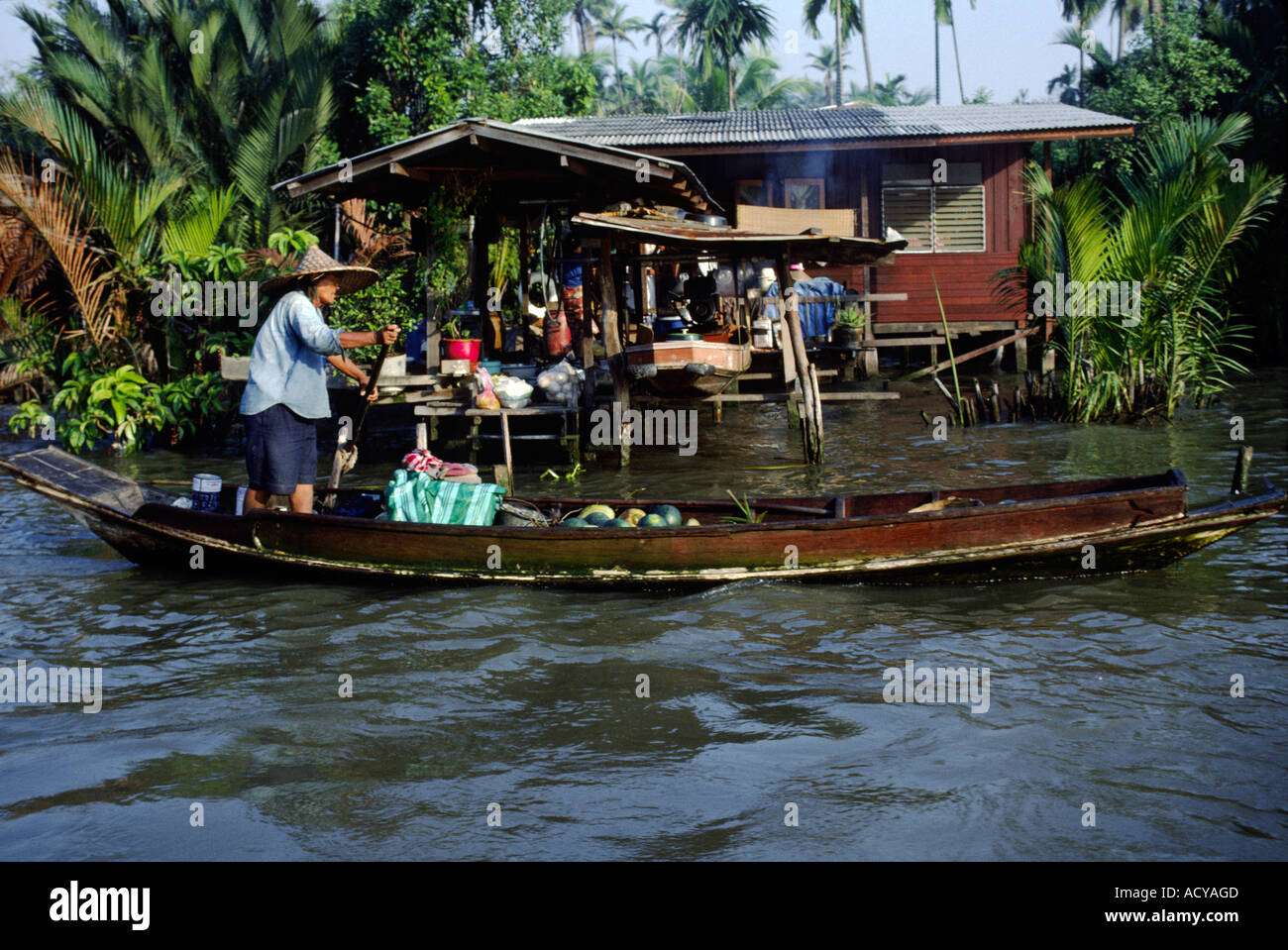 Thai merchant sells fruit from his boat at the FLOATING MARKET BANGKOK THAILAND Stock Photo