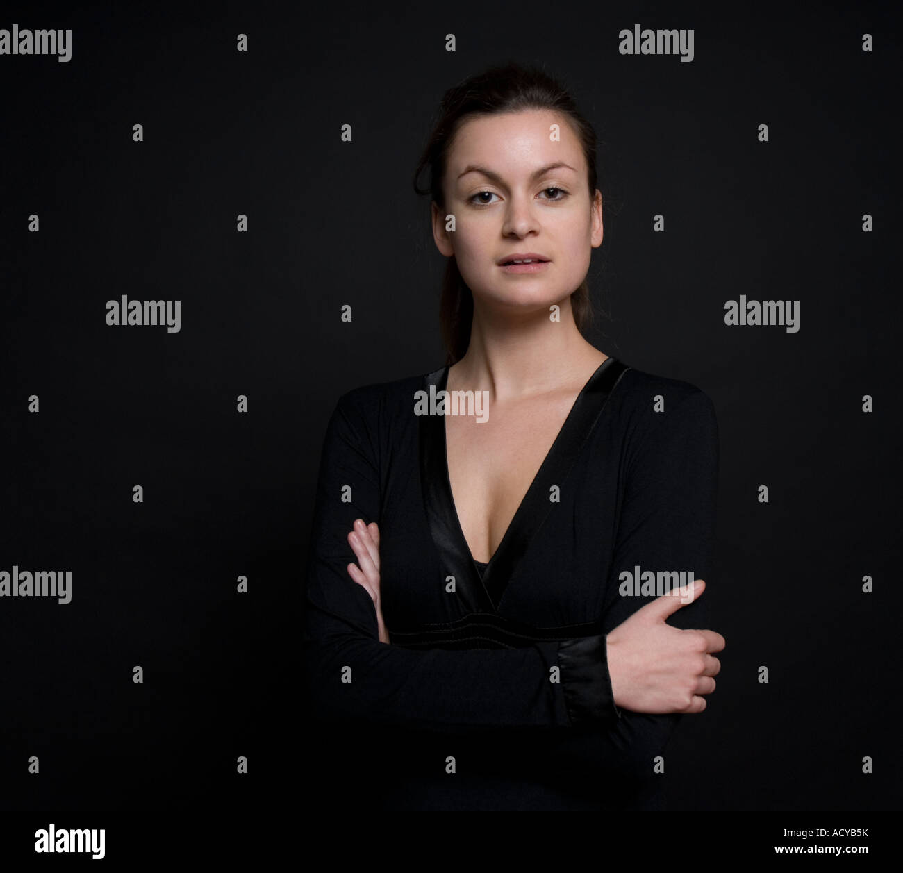 Young woman standing proud against plain back ground Stock Photo - Alamy