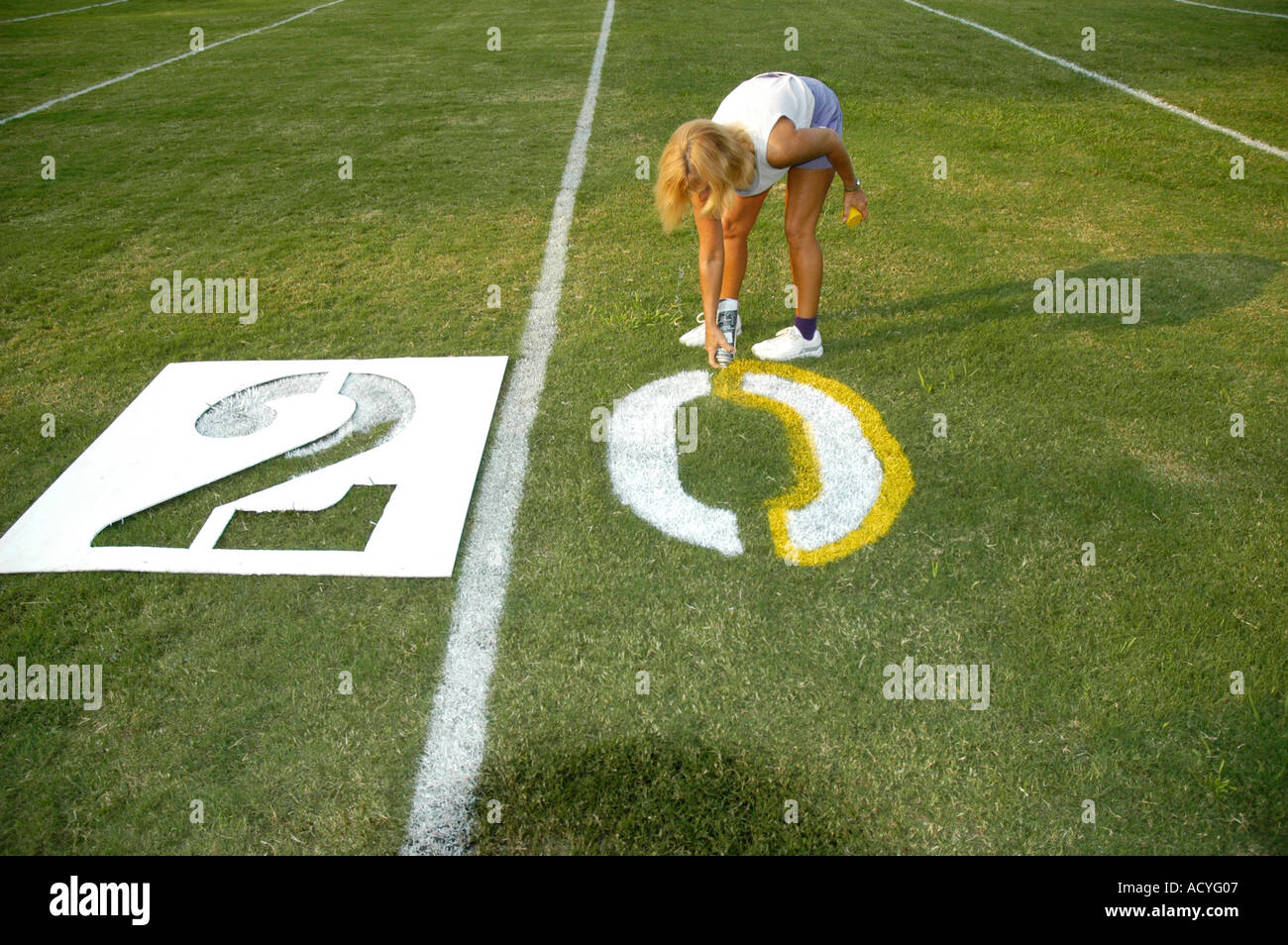 Painted yardage lines of football field some being painted by real