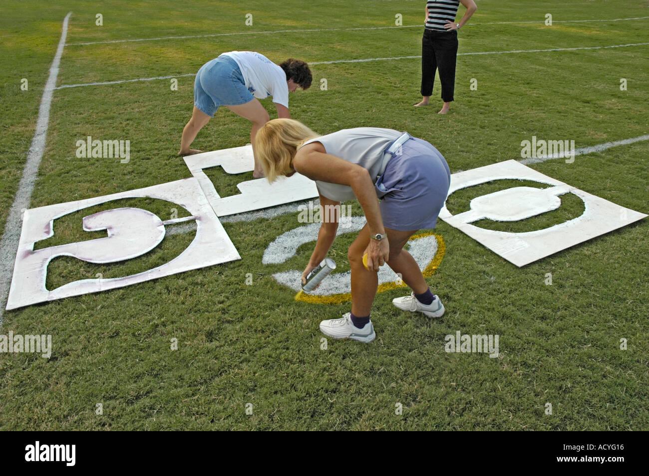 Painted yardage lines of football field some being painted by real