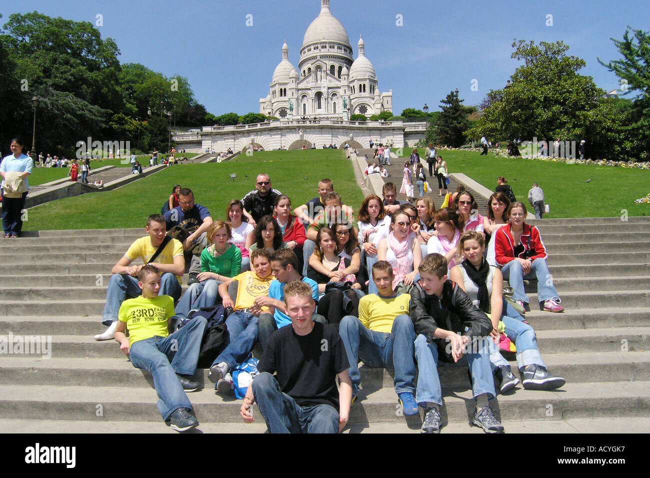 a party of students posing for camera in front of Sacre Coeur Paris Stock Photo