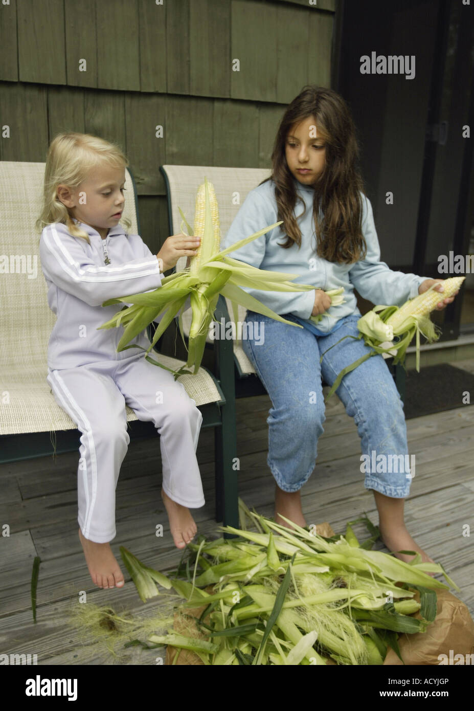 Two children shucking corn Stock Photo Alamy
