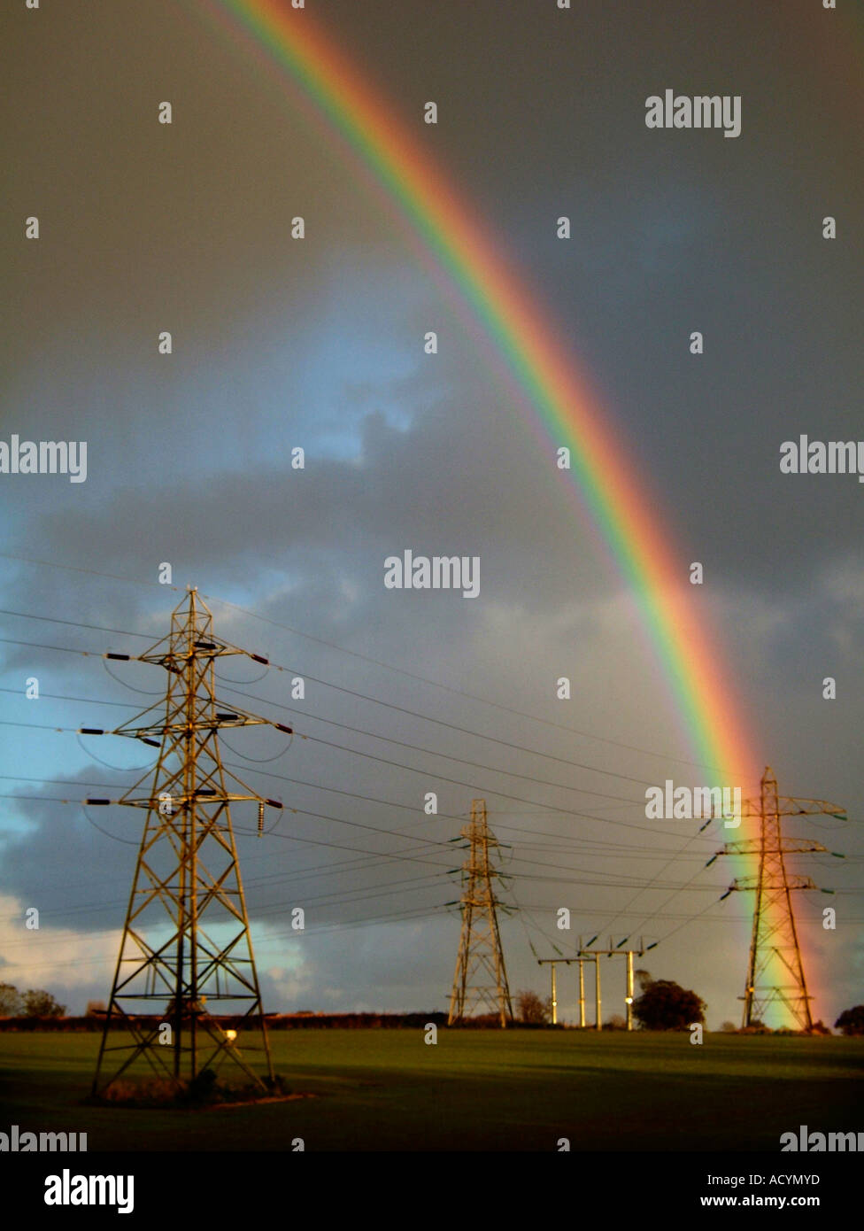 rainbow over electricity pylons Stock Photo