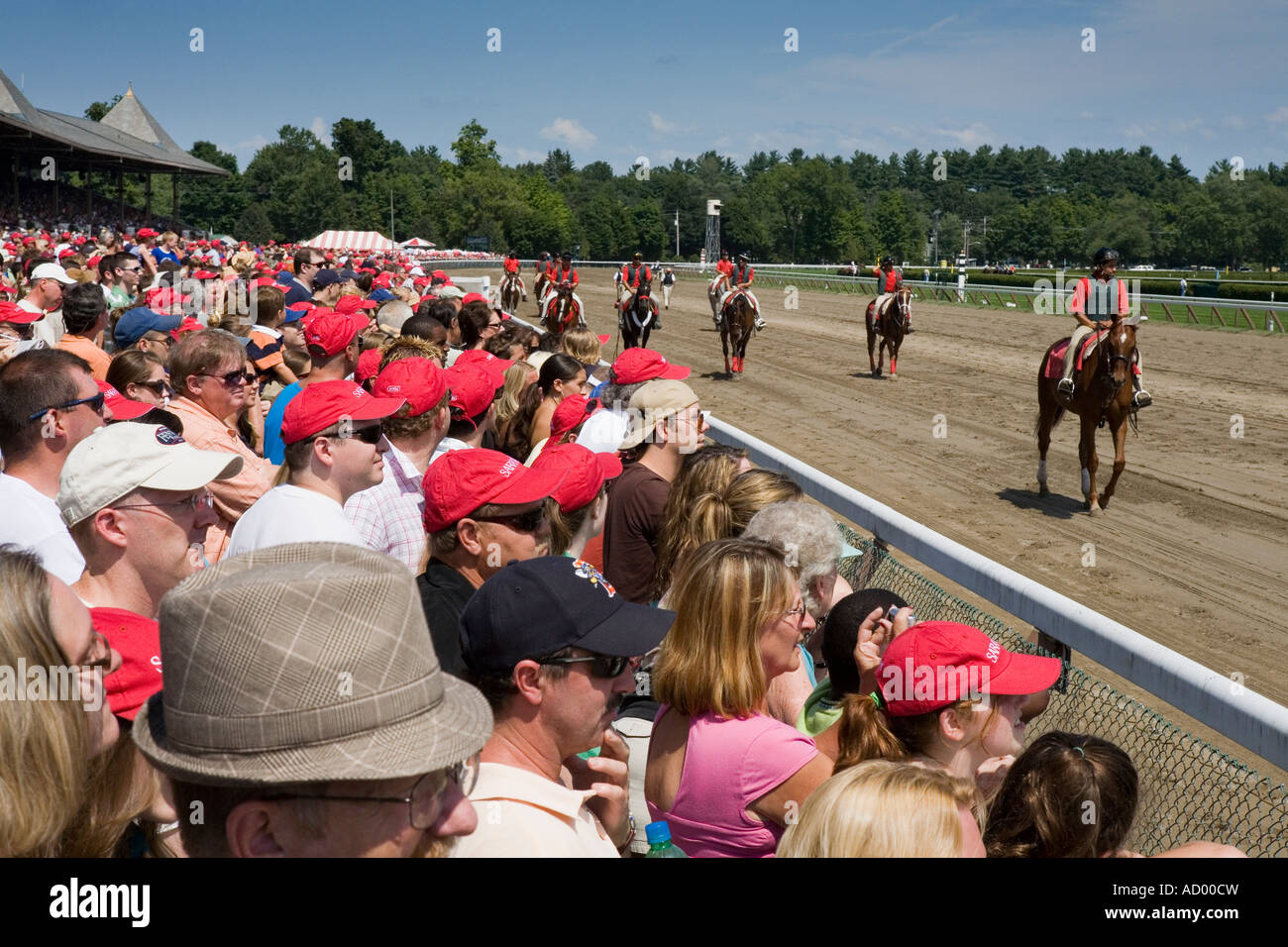 Fans in red hats watching horses walking to starting gate Saratoga Springs New York Stock Photo