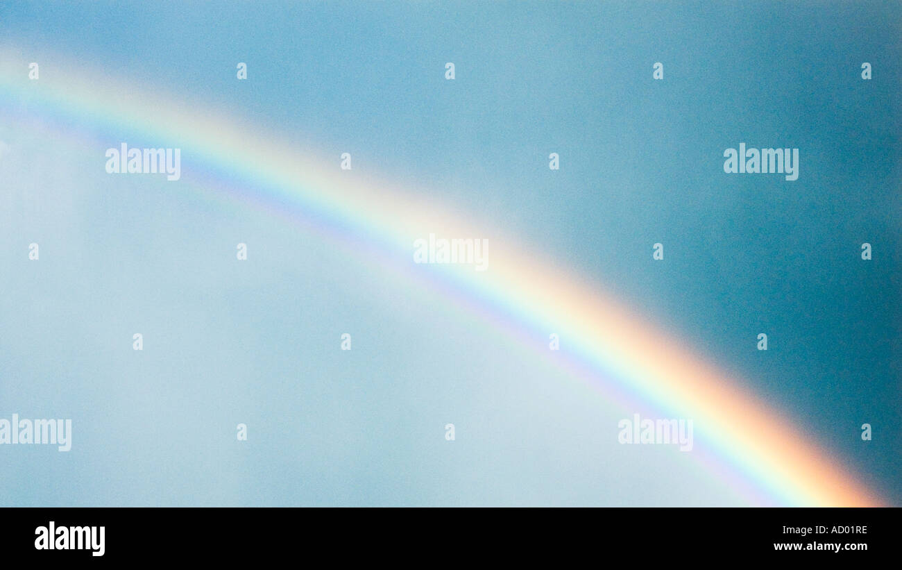 Rainbow across blue sky Stock Photo - Alamy