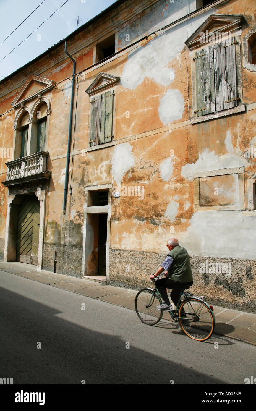 old man cycling in the streets of Bassano Del Grappa in Italy just north or Venice Stock Photo