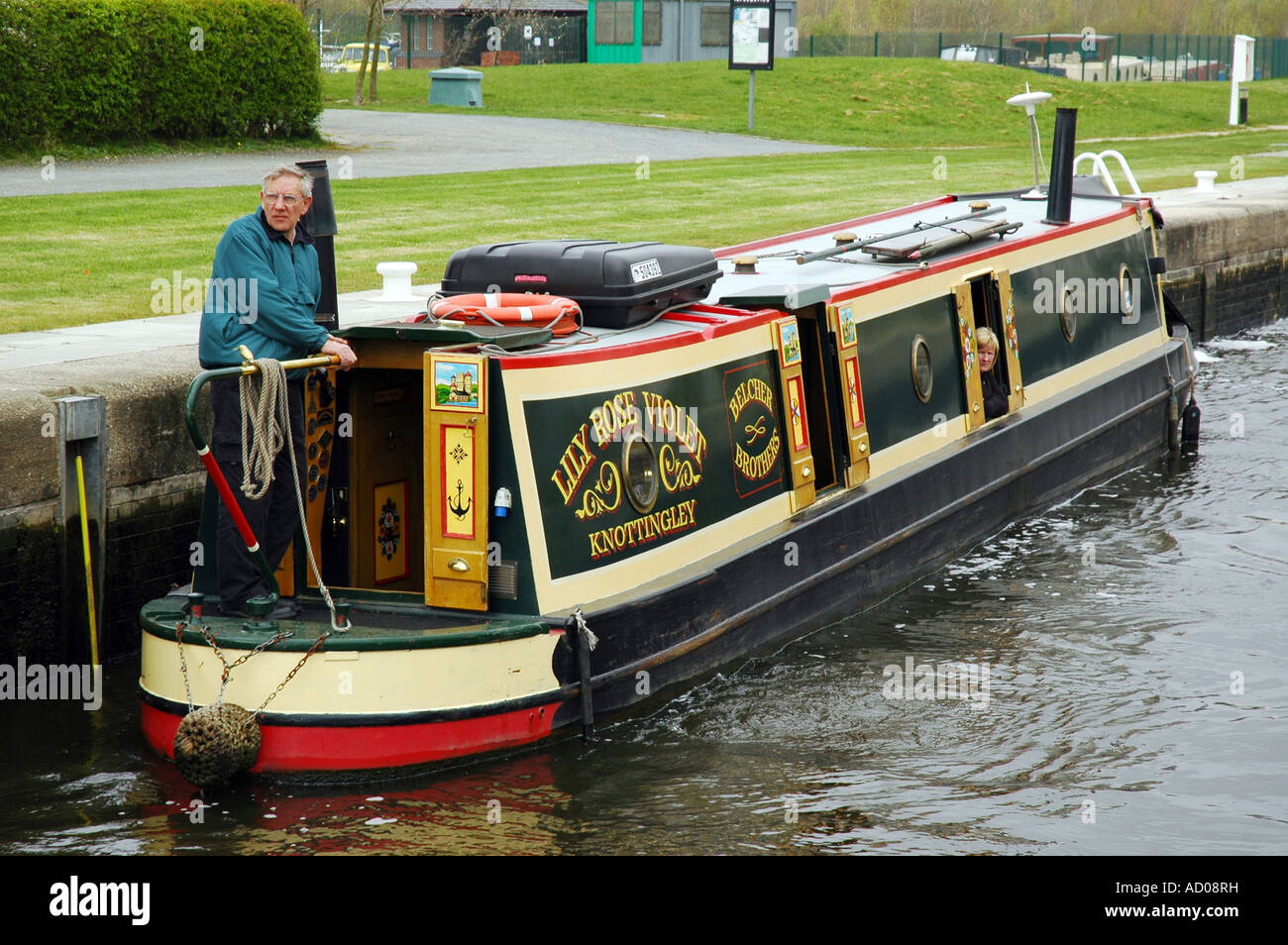 Narrowboat prepares to exit Lemonroyd Lock, Leeds. The couple are aboard their narrowboat, Lily Rose Violet. Stock Photo