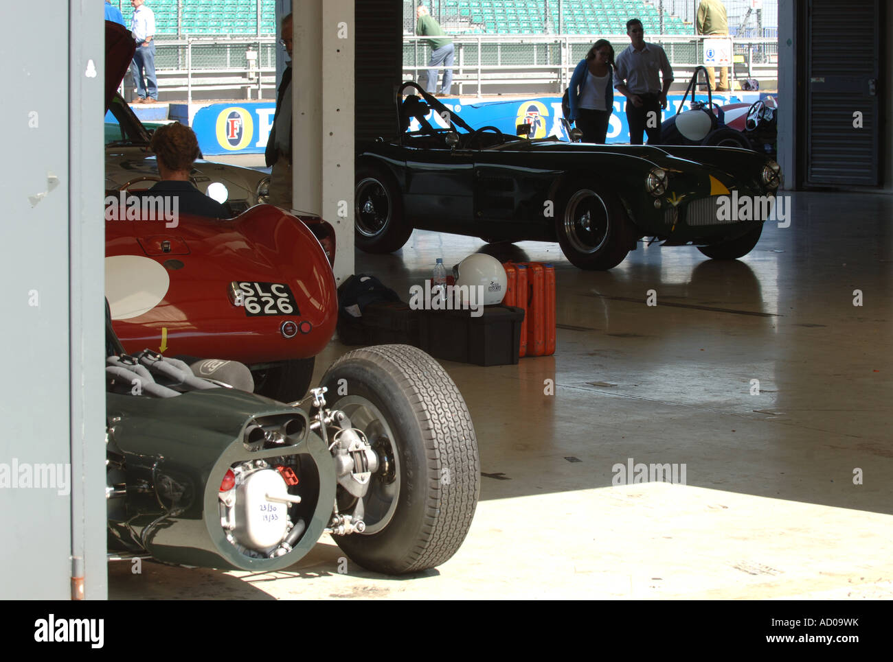Historic racing cars in a pit lane garage at Silverstone prepare to go