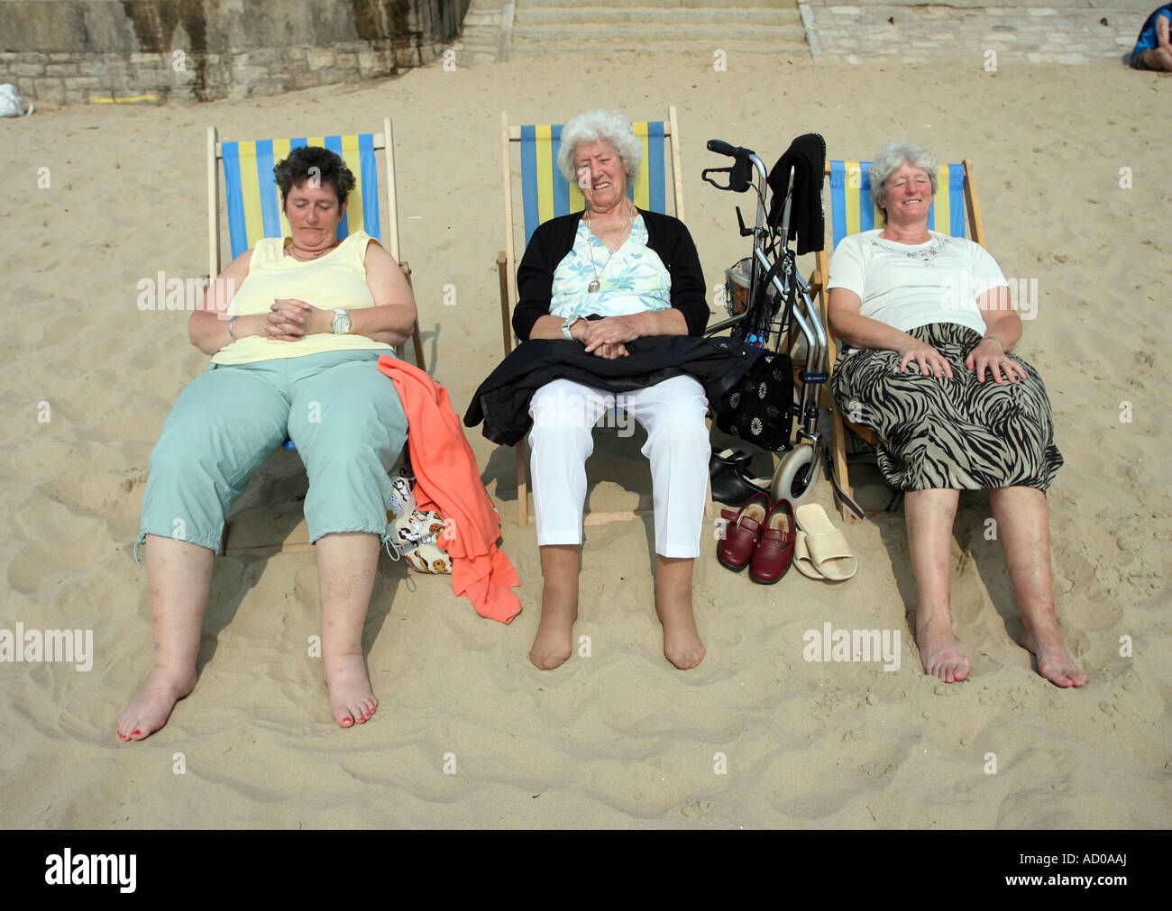 Three Old Women relaxing on Bournemouth beach Hampshire UK Stock Photo