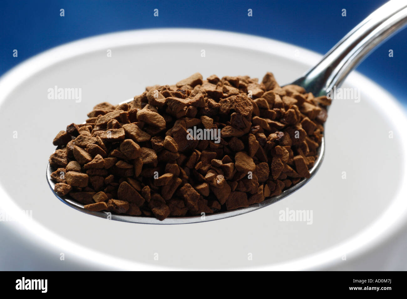 Detail showing freezedried coffee granules on a metal spoon about to