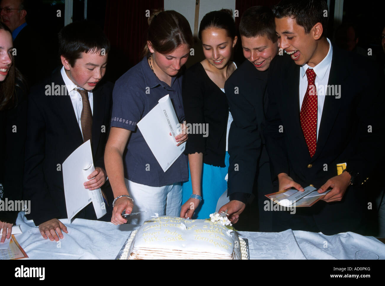 Celebrating Confirmation Young People Cutting Cake Together - Joy Stock Photo