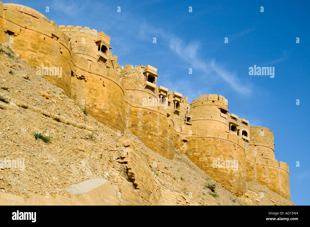 Horizontal wide angle of several of the 99 yellow sandstone bastions of Jaisalmer Fort against a bright blue sky Stock Photo