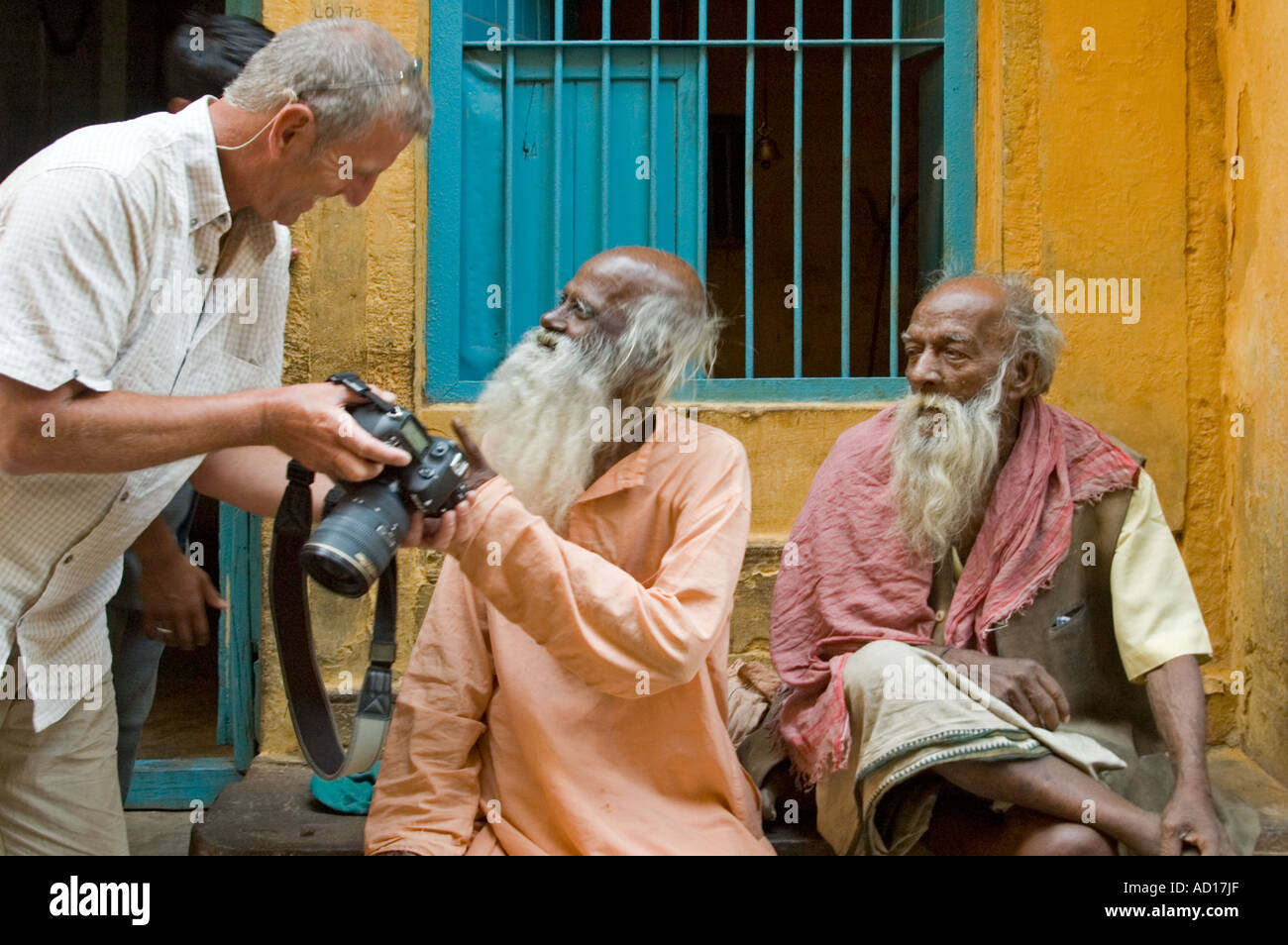 Horizontal close up of tourist showing elderly Indian men digital photos of themselves from the back of his DSLR camera Stock Photo