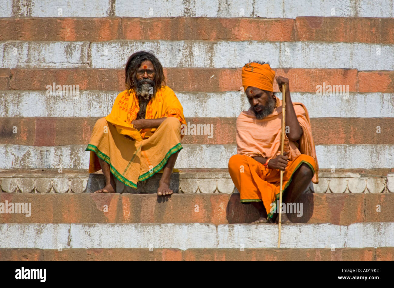 Two Sadhus (holymen) in traditional saffron ochre clothes sit at the