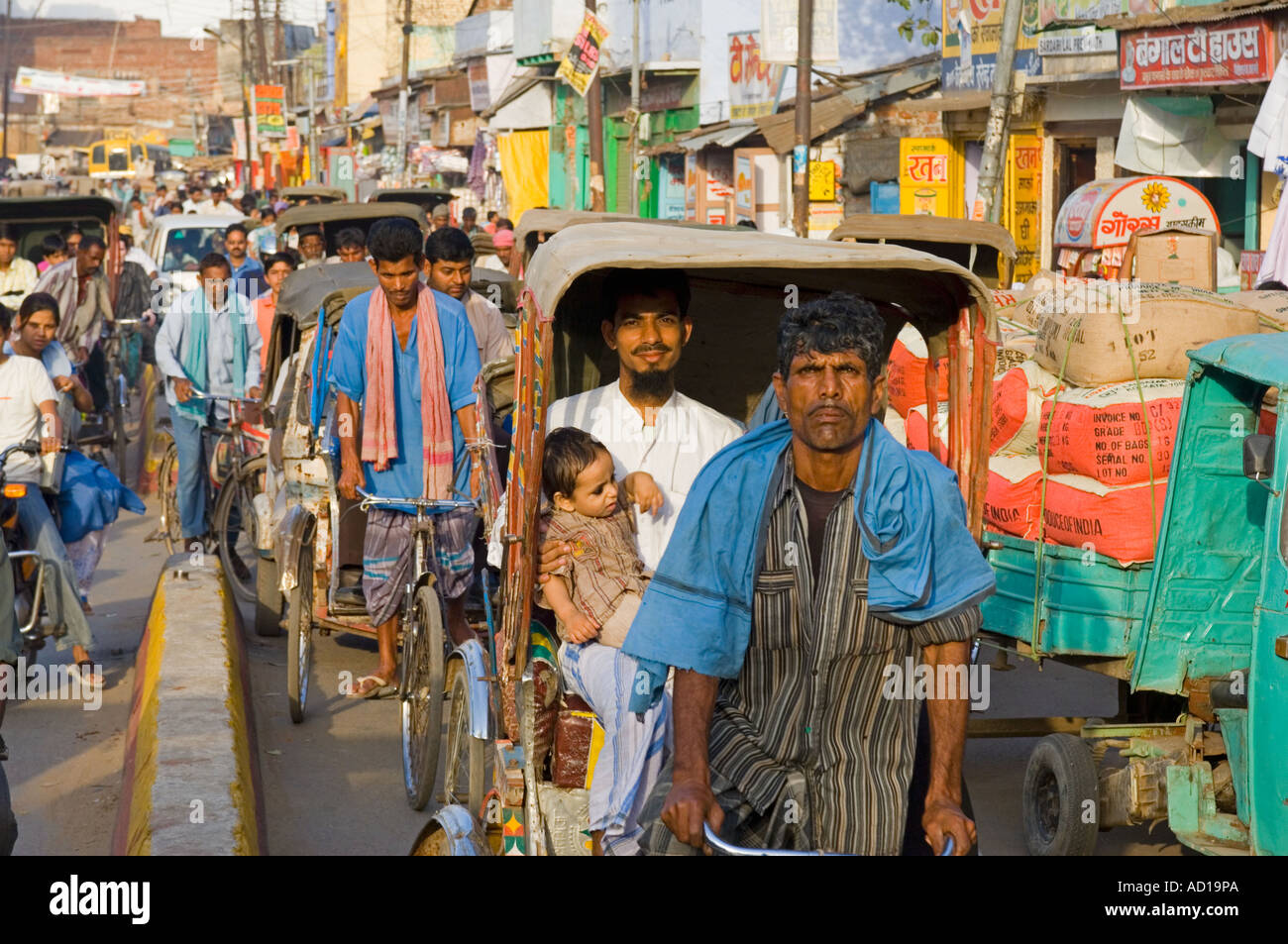 A compressed perspective view of a busy street in Varanasi with people on  cycle rickshaws and bicycles. Stock Photo