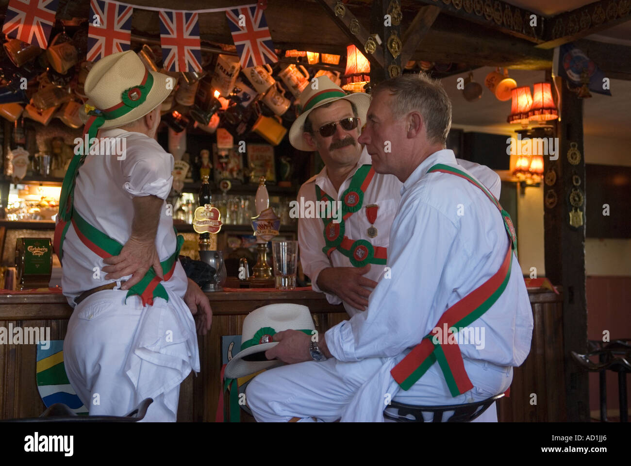 Morris dancing, the Thaxted Morris Ring team taking a lunch break in  local village pub, chatting ordering pints of beer. Essex UK 2000s HOMER SYKES Stock Photo